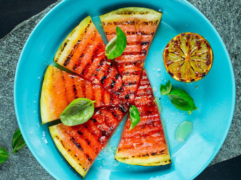 ENKELT OG DIGG: Legg vannmelon på grillen med litt lime over - og du har nydelig tilbehør til sommerens fisk- eller skalldyrsmåltid. Få oppskriften her! Foto: Meny