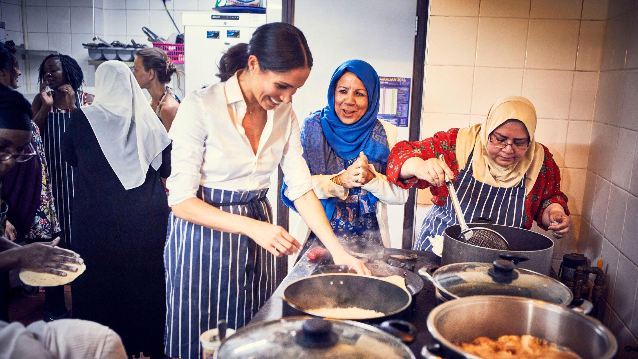 MATGLEDE: Meghan Markle lager mat sammen med kvinnene på Hubb-kjøkkenet. Foto: Jenny Zarins/Det britiske kongehuset/Reuters