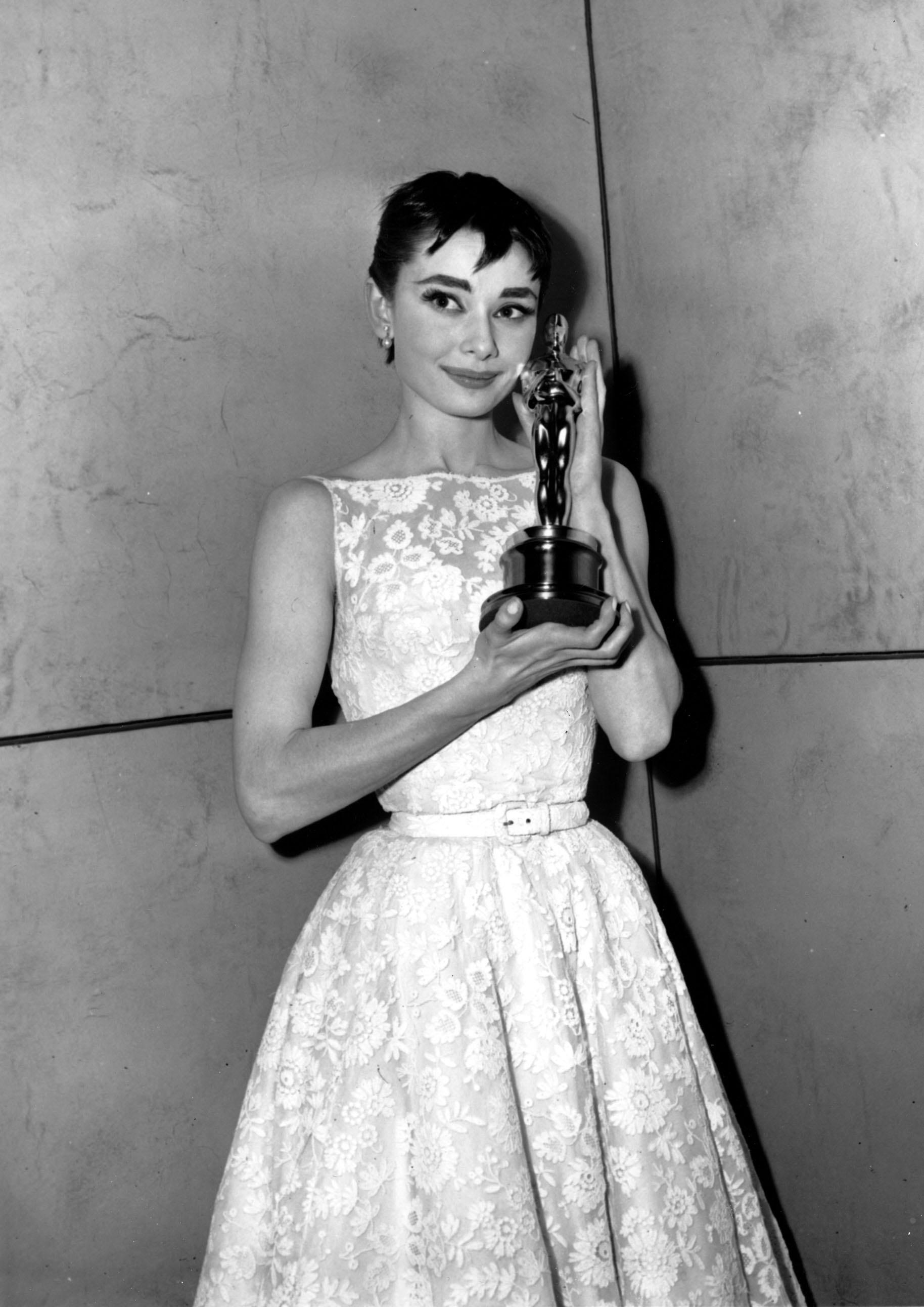 IKONISK: Audrey Hepburn i en hvit blondekjole med markert midje. 