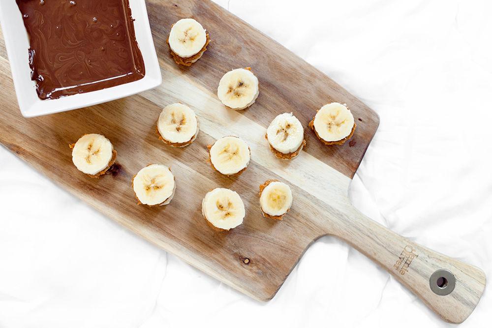 Lag små sandwicher av bananskivene med peanøttsmør mellom, og smelt sjokoladen i vannbad.