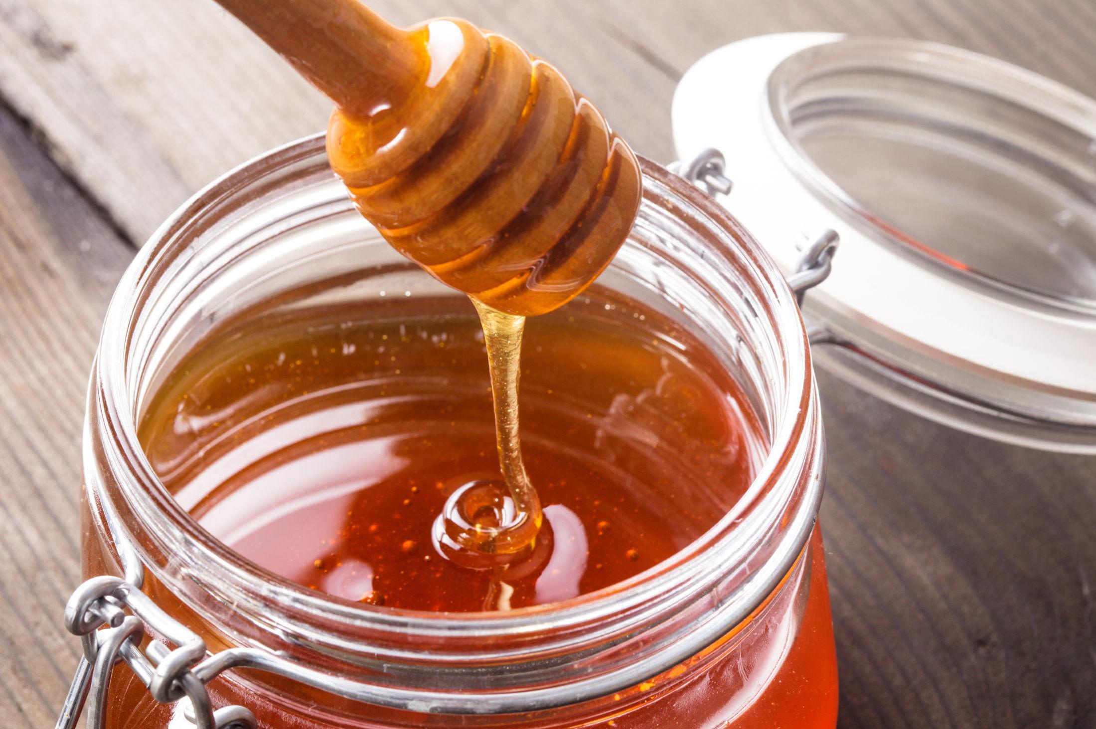 TIPS: Hvis honningen er krystallisert, kan du sette en åpen honningboks i varmt vann og rør erundt. Foto: Oksana Shufrych / Shutterstock / NTB Scanpix