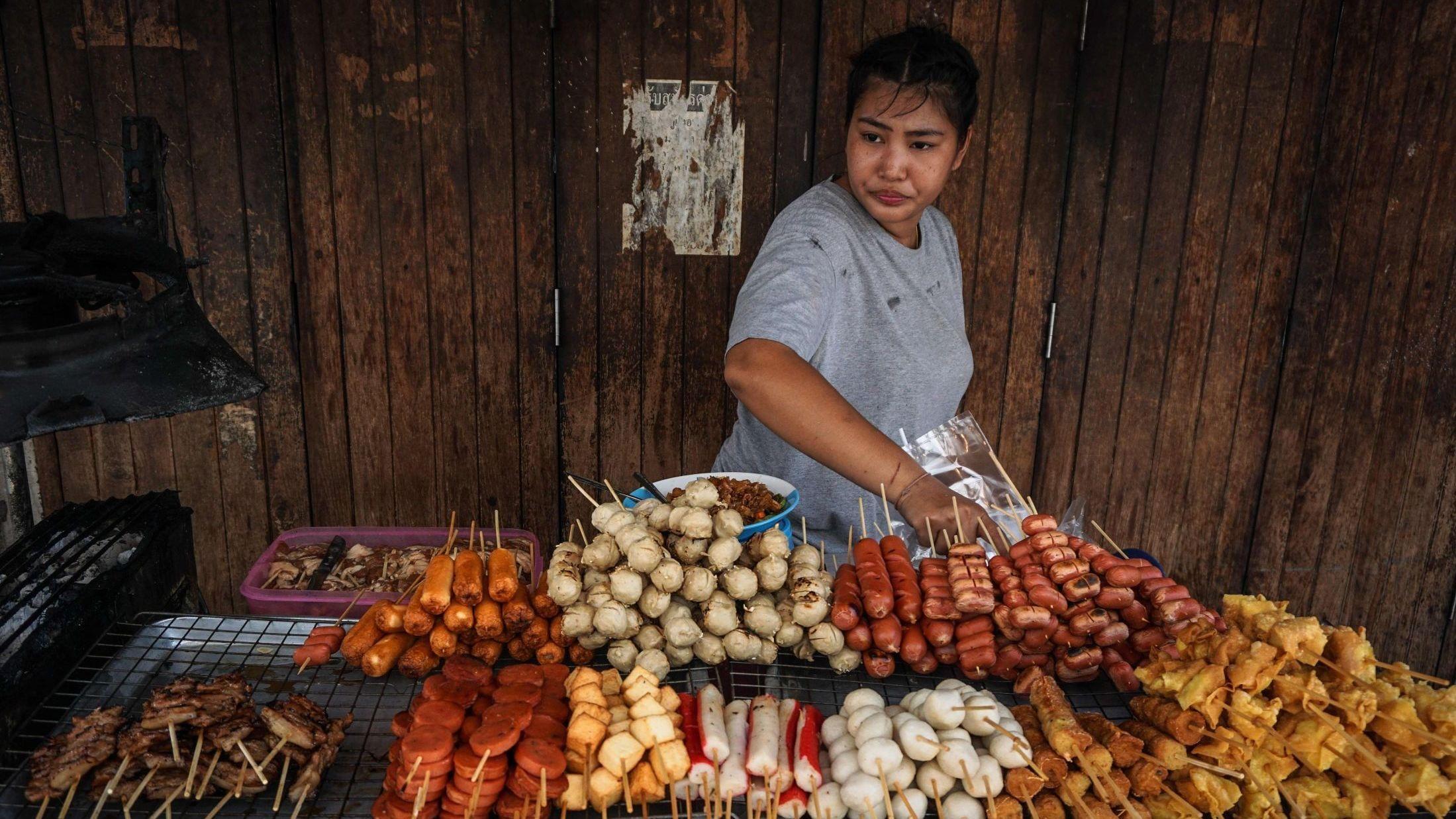 FORBUD: En kvinne legger klar snacks i Pratunam-distriktet i Bangkok.  Foto: Lillian Suwanrumpha/AFP Photo