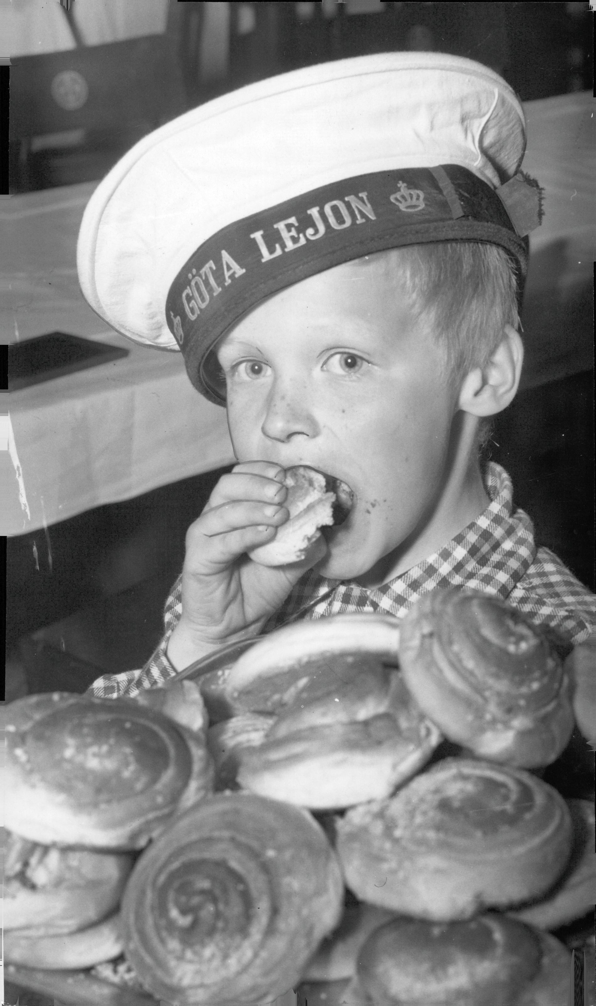 Även 1952 var kanelbullen ett självklart val. Folkskolepojkar på kryssaren HMS Göta Lejon och jagaren HMS Uppland. Marinlottor bjöd på saft och bullar, som pojken på bilden lät sig väl smaka.