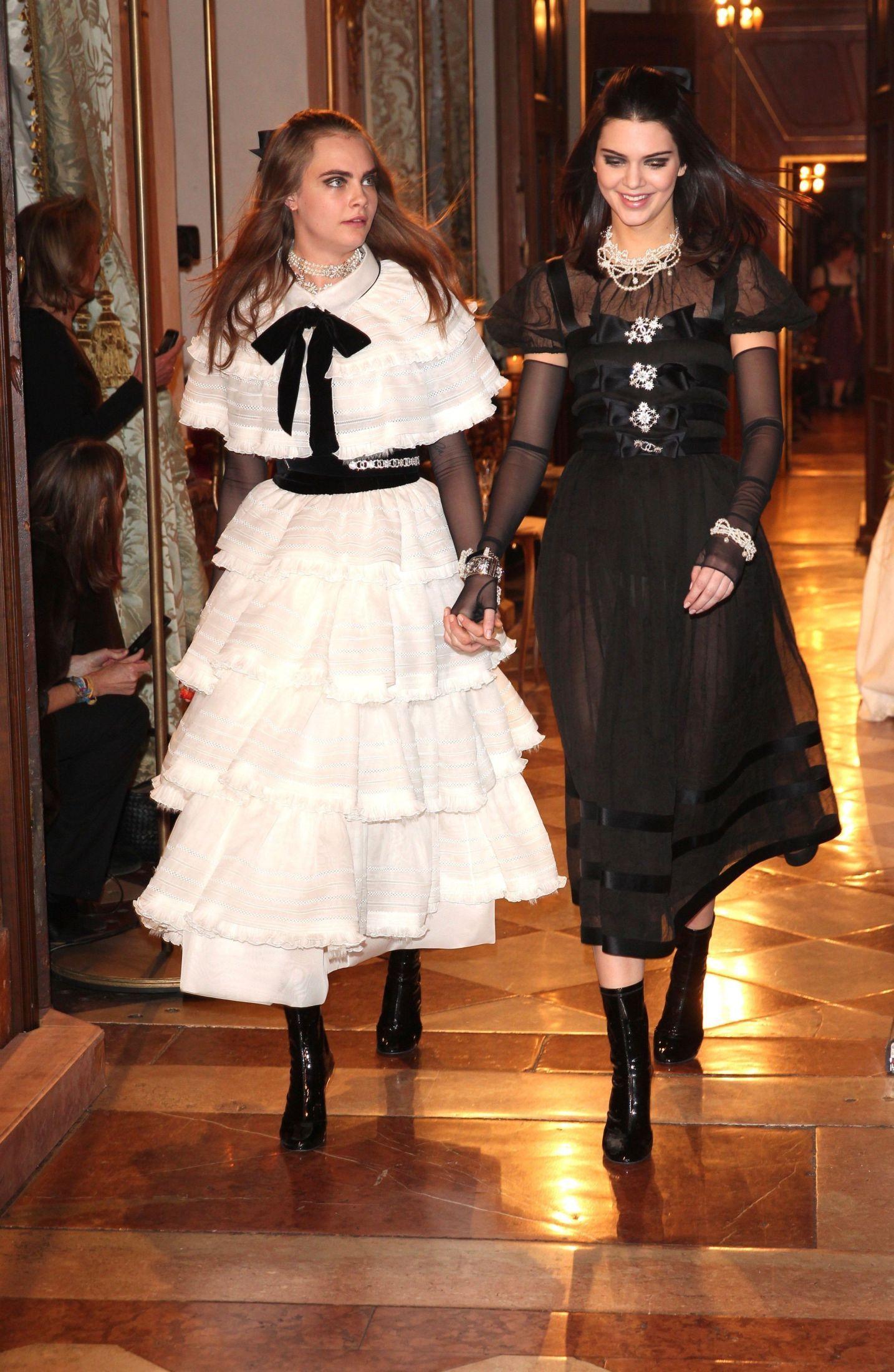 HÅND I HÅND: Venninnene Cara Delevingne (22) og Kendall Jenner (19) avslutter Chanel sin Pre-Fall 2015 visning hånd i hånd, iført luksus kjoler. Foto: Getty Images