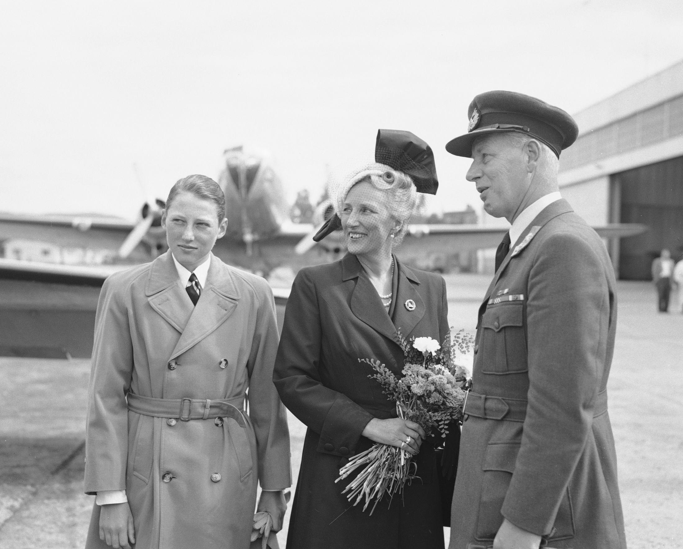 Kronprinsesse Märtha i nok et festlig hodeplagg, og prins Harald i kledelig trenchcoat, på reise til Helsingfors i 1952. Foto: Jan Stage/NTB