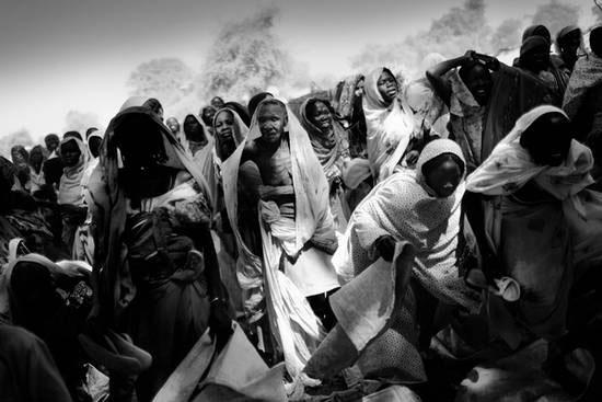 Habile, østre Tsjad, november 2006. Interne flyktninger venter på matrasjoner nær landsbyen Habile. Habile pleide å være en liten landsby med noen få hundre innbyggere, men nå har titusenvis av mennesker søkt tilflukt der på grunn av angrep fra Janjaweed. © Jan Grarup / NOOR
