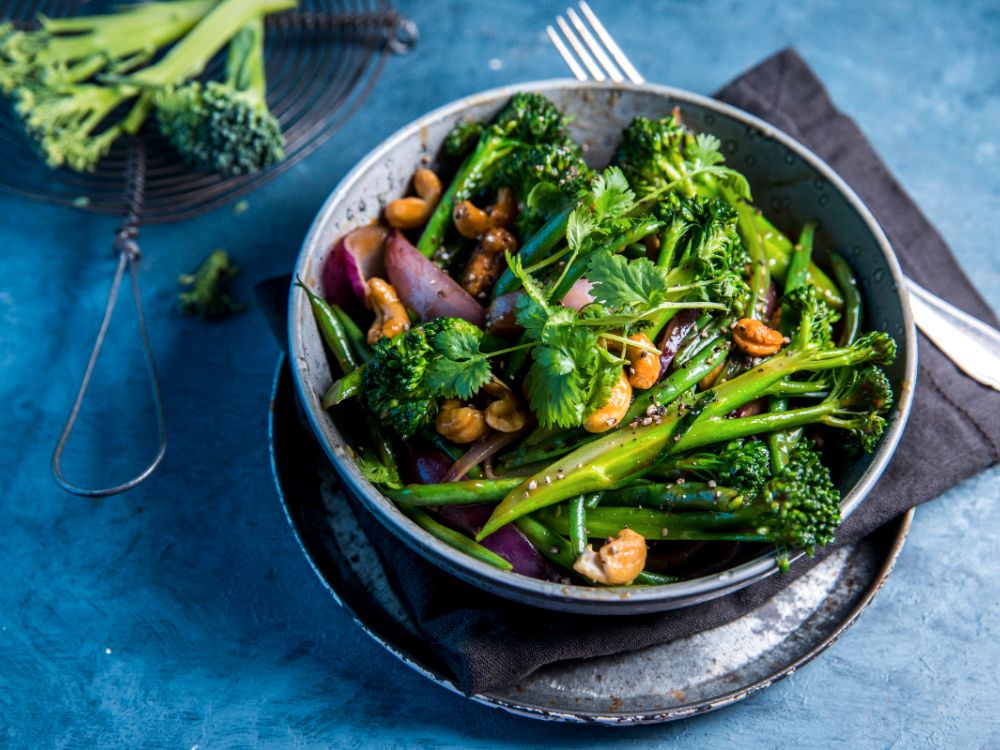 Grönsakswok med broccoli, långbönor, rödlök och cashewnötter.