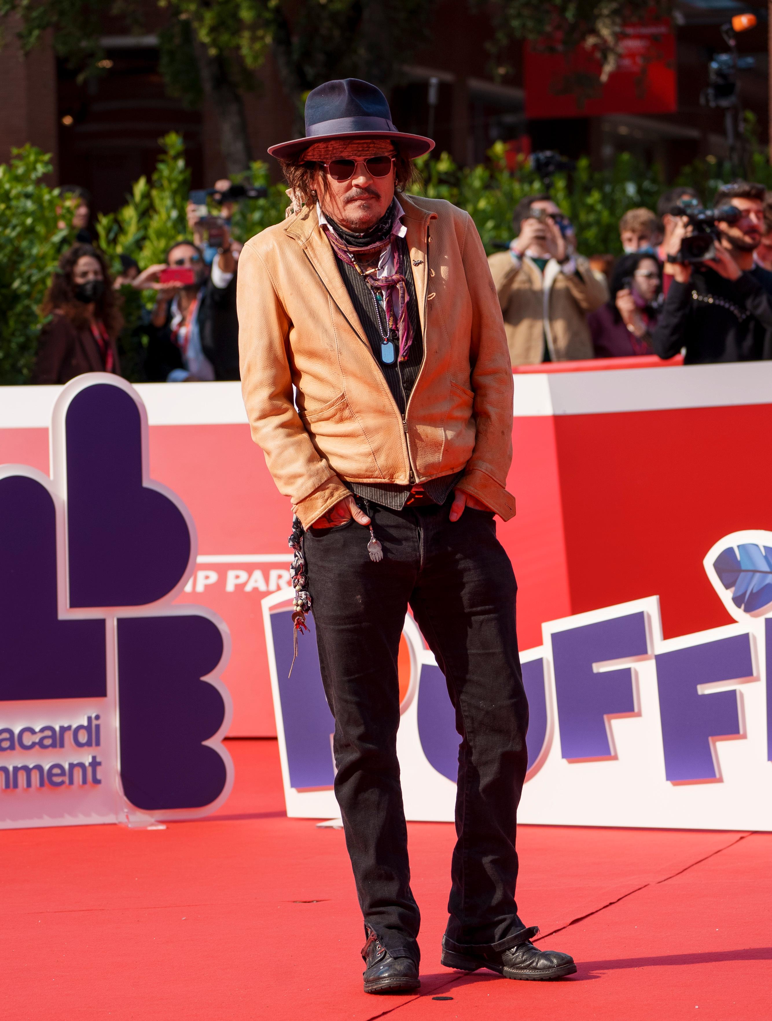 2021: Johnny Depp møtte opp på premieren av «Puffins» iført lysebrun jakke og svart bukse. Han toppet premiere-looken med sine gode, gamle tilbehørsfavoritter: hatt, kjeder og skjerf.