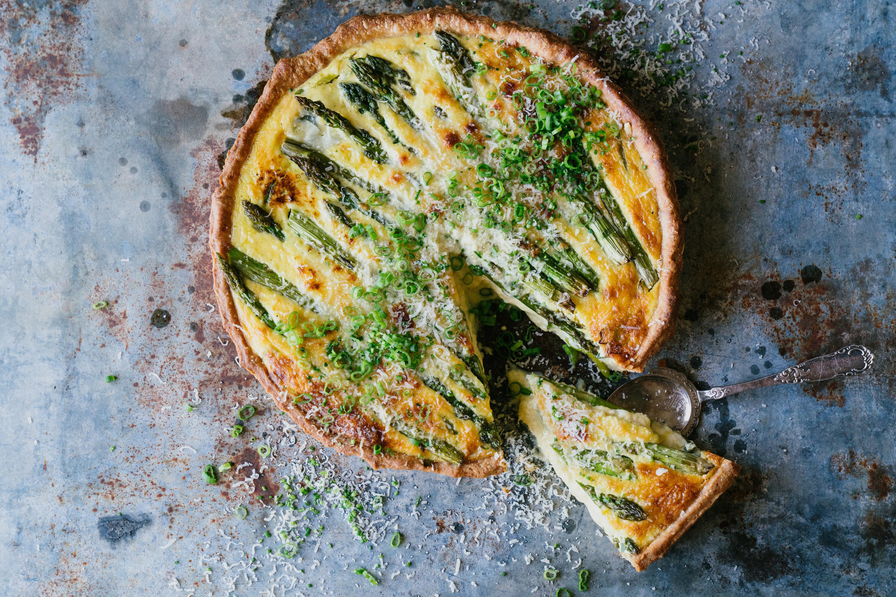 VÅRLIG: Årets første asparges er et sikkert vårtegn. Her er har den fått selskap av ost og vårløk i en deilig pai.