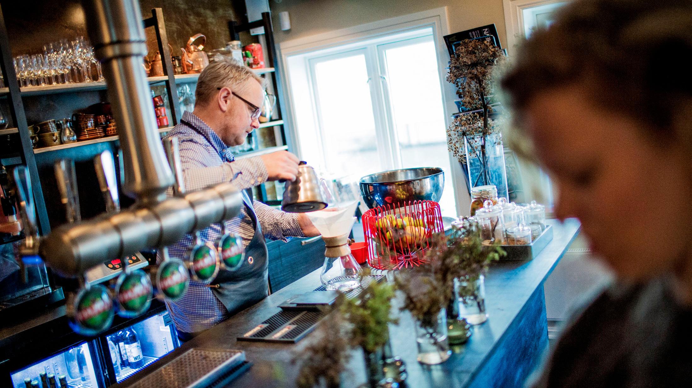 ENKELT: Spiserommet på Jossa Mat og Drikke minner mer om en kaffebar enn en rastaurant, Og bak baren står Steffen Kolstad og serverer kaffe. Foto: Øyvind Nordahl Næss