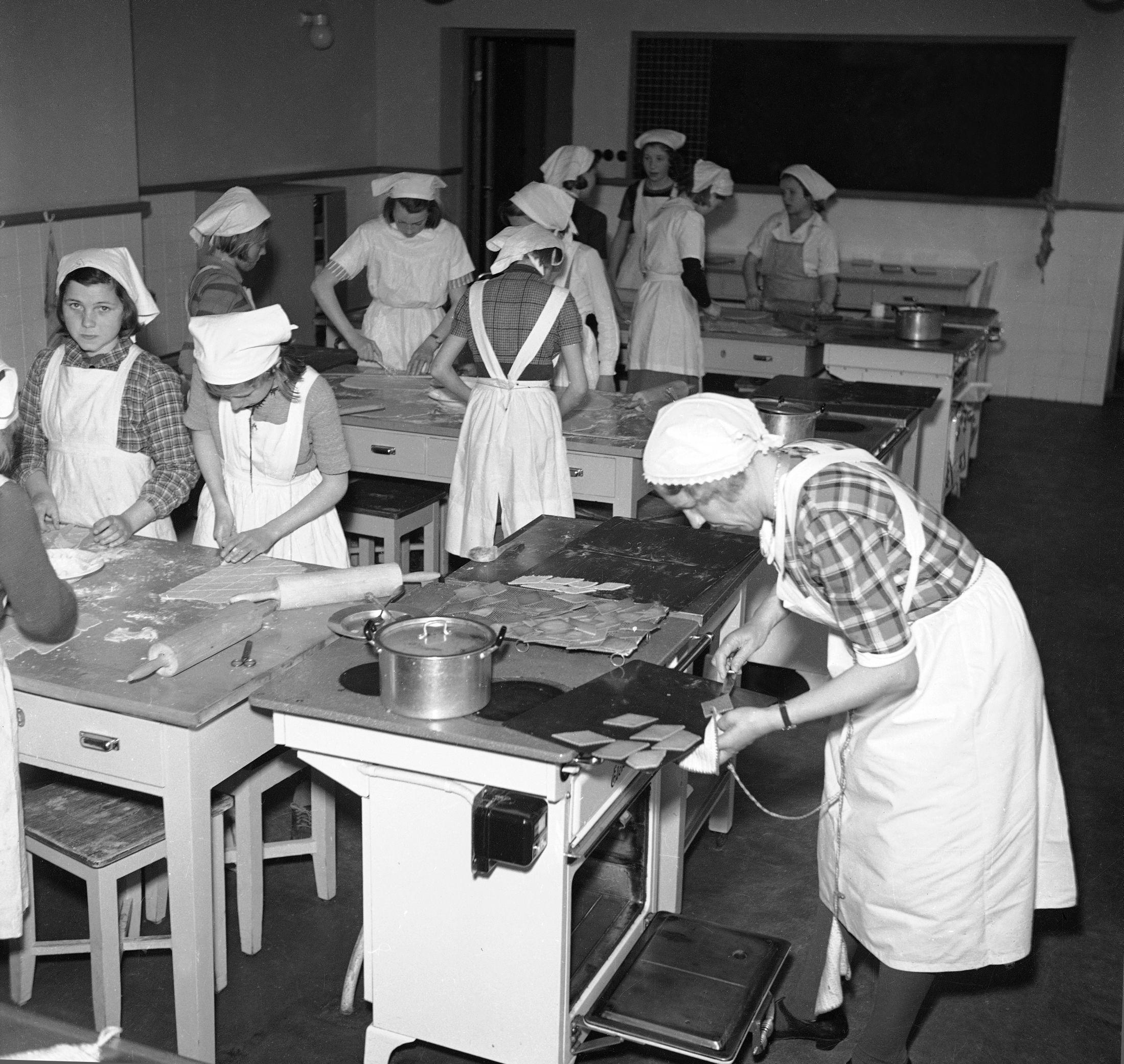 SKOLEKJØKKEN 1946: På Smestad skole i Oslo er jentene er iført forklær og hetter og er i gang med å bake pepperkaker og sirupssnipper. Foto: NTB Scanpix