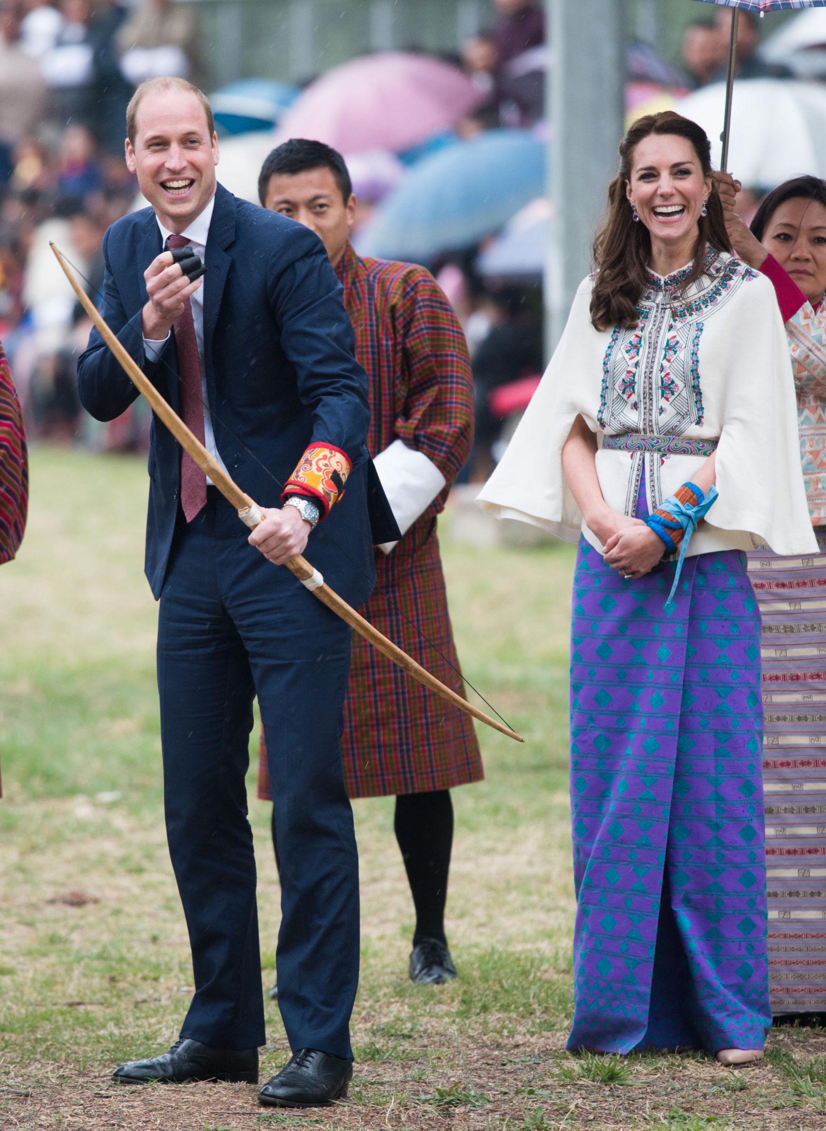 LEKENT: Den orientalske blusen Kate hadde på seg da hun og prins William skjøt med pil og bue, er fra Paul & Joe, mens omslagsskjørtet er et tradisjonelt bhutansk plagg. Foto: Getty Images