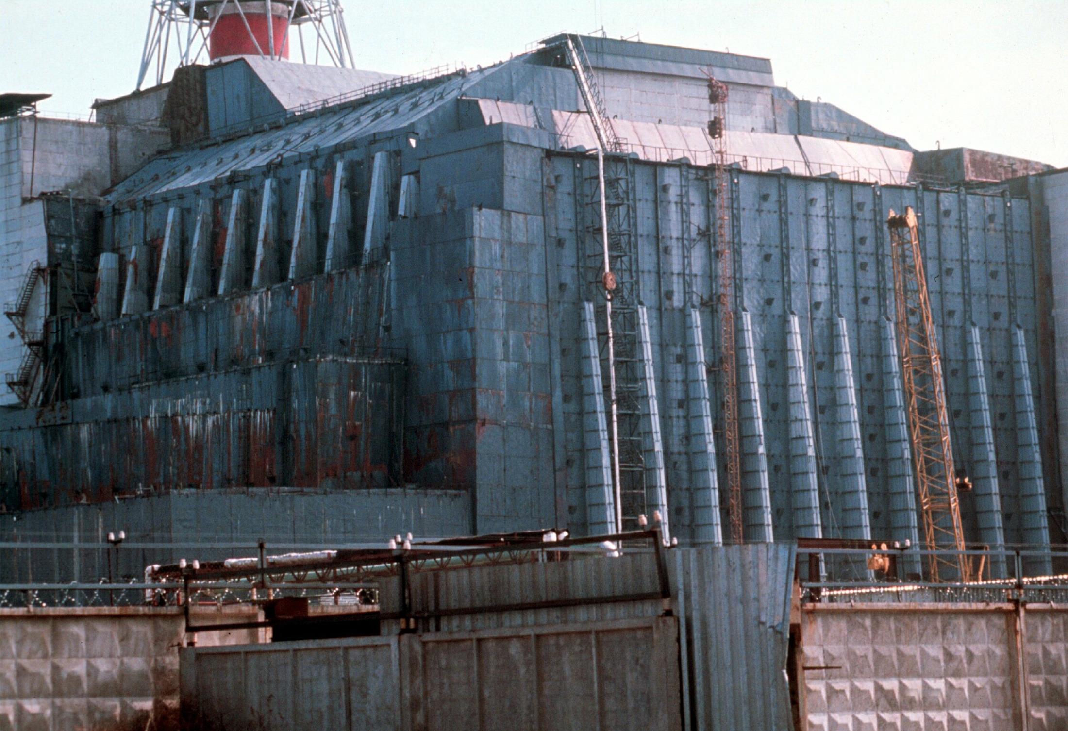 Etter en katastrofal ulykke i Tsjernobyl-kraftverkets reaktor nummer fire i 1986 ble denne enorme betongsarkofagen konstruert i full fart rundt reaktoren, for å hindre radioaktivt materiale i å slippe ut. Den er nå i ferd med å erstattes av en enorm stålsarkofag, som skal stå der i minst 100 år fremover.Foto: NTB scanpix