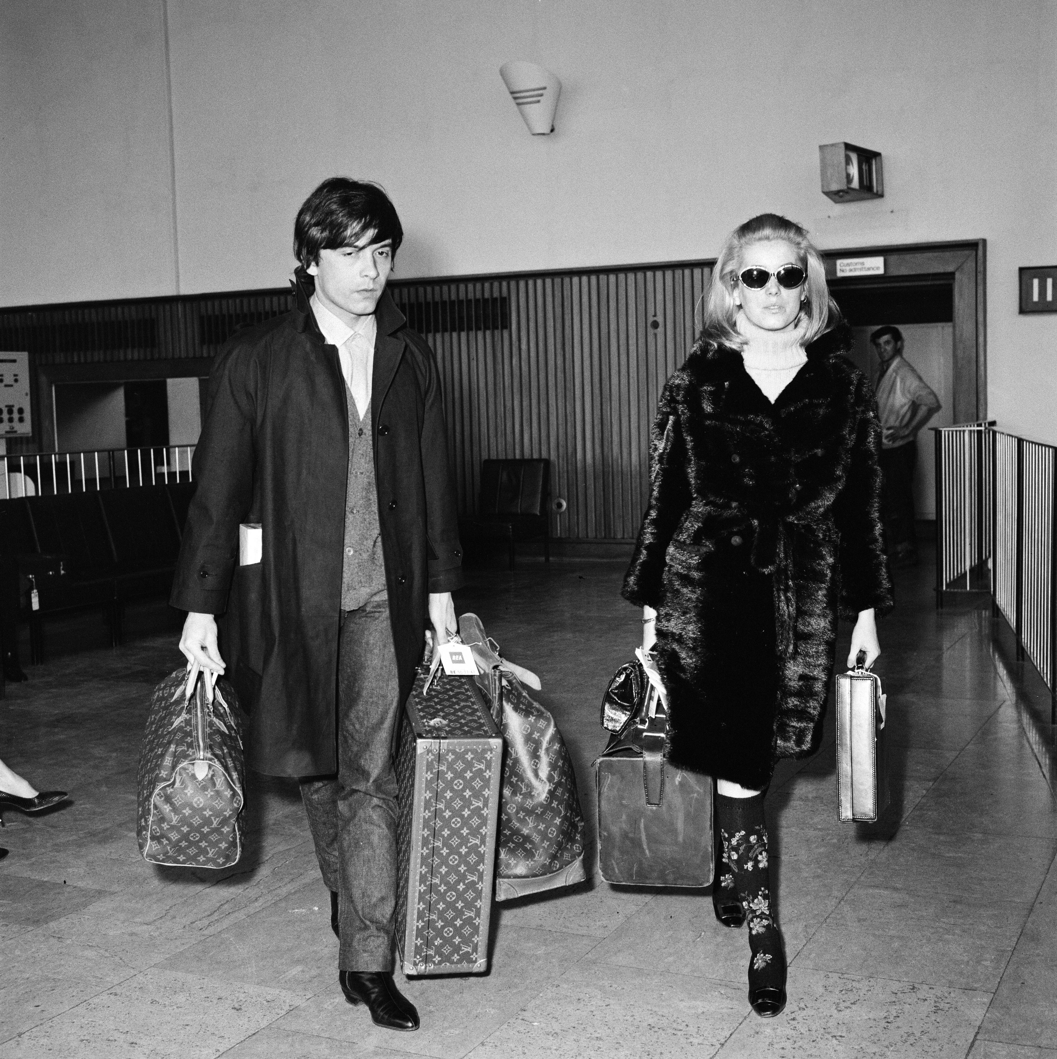 Motefotograf David Bailey og skuespiller Catherine Deneuve på flyplassen i London i 1966 – med LV-bagasje. Deceuve brukte «Speedy» i ulike størrelser.