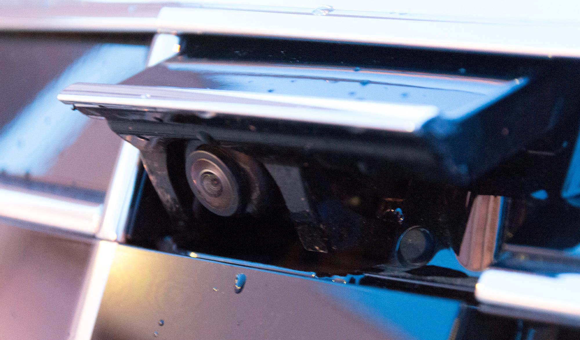 Bilen har et kamera som spretter ut av grillen når parkeringsfunksjonene aktiveres. Sammen med dette jobber et kamera under hvert sidespeil, og et ryggekamera bak. Dermed kan bilen vise deg parkeringen i et datagenerert fugleperspektiv. Foto: Kristoffer Møllevik, Tek.no
