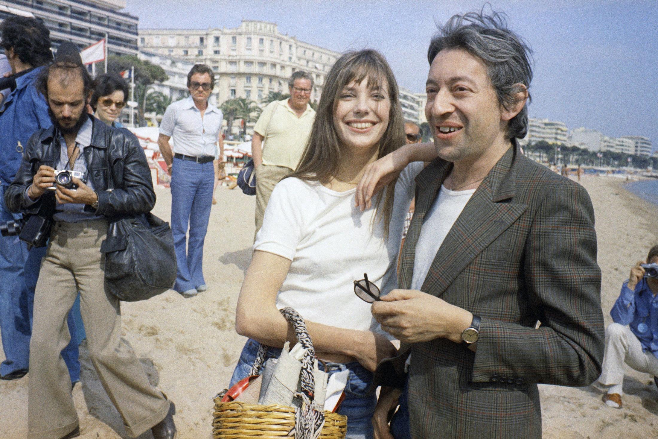 NONCHALANT CHIC: Britiskfødte Jane Birkin ble selve symbolet på nonchalant chic på 70-tallet. Her er hun avbildet på stranden med den velkjente stråvesken og ektemannen Serge Gainsbourg, under filmfestivalen i Cannes i 1974. Foto: NTB scanpix