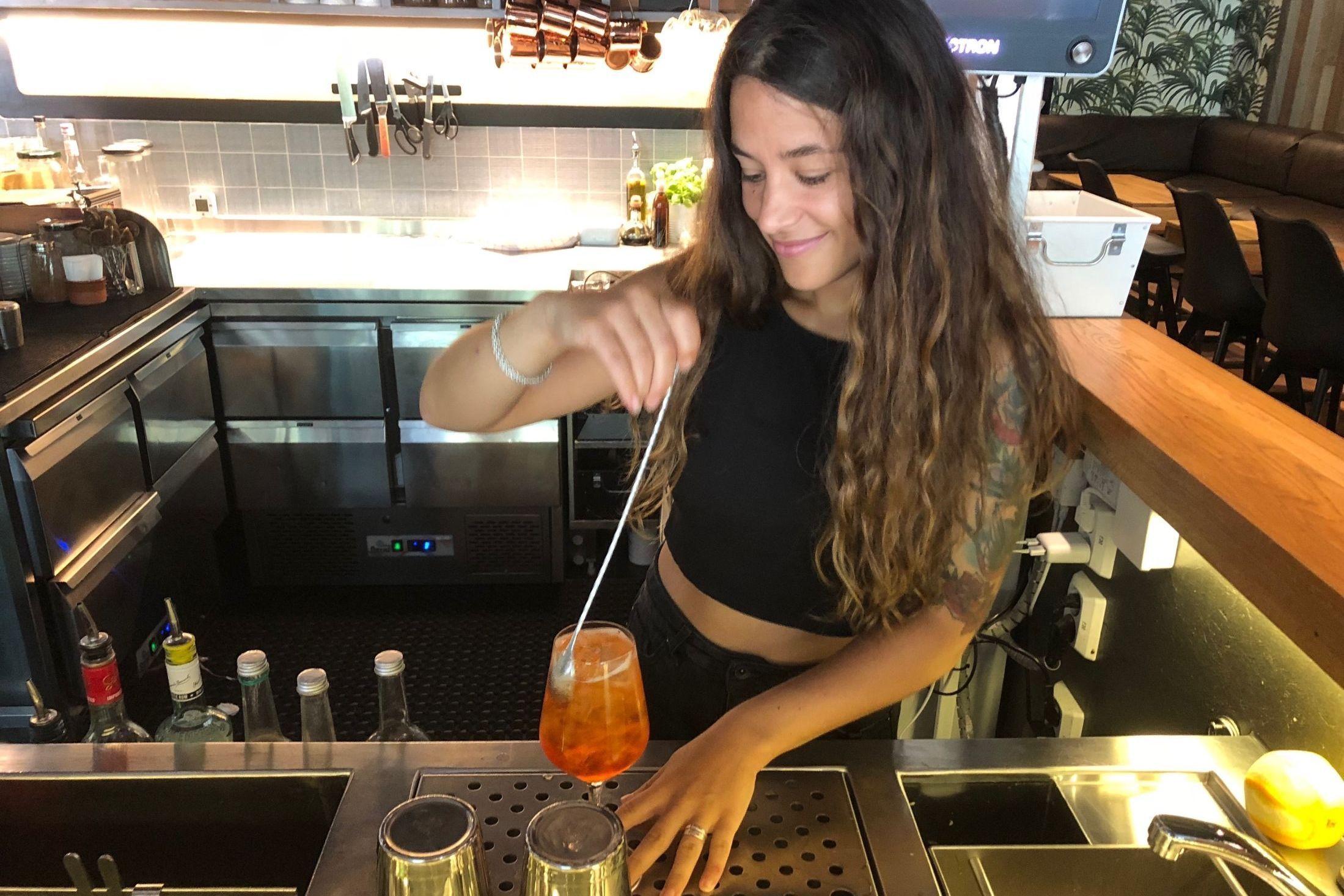 SPRITZ AL CAFÈ: Medarbeider Denise Flores (28) lager den klassiske Aperol Spritz med en kaffetvist. Foto: Malene Emilie Rustad