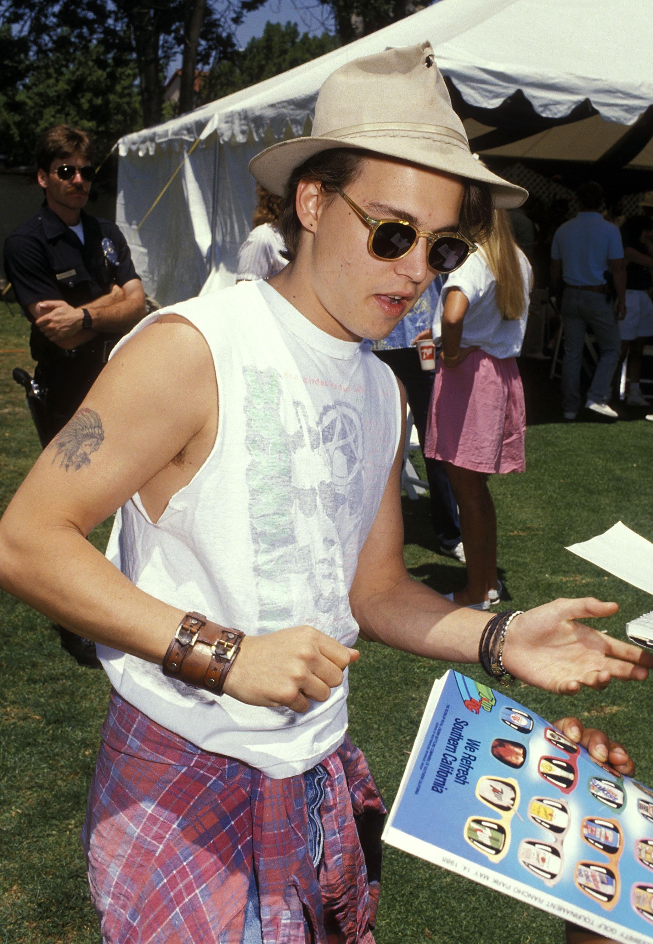 FAVORITTANTREKK: Hatt, armbånd, solbriller og en skjorte knytt rundt livet må være Depps favorittlook. Han har vært trofast mot denne stilen i alle år. Her er han i California i 1988.