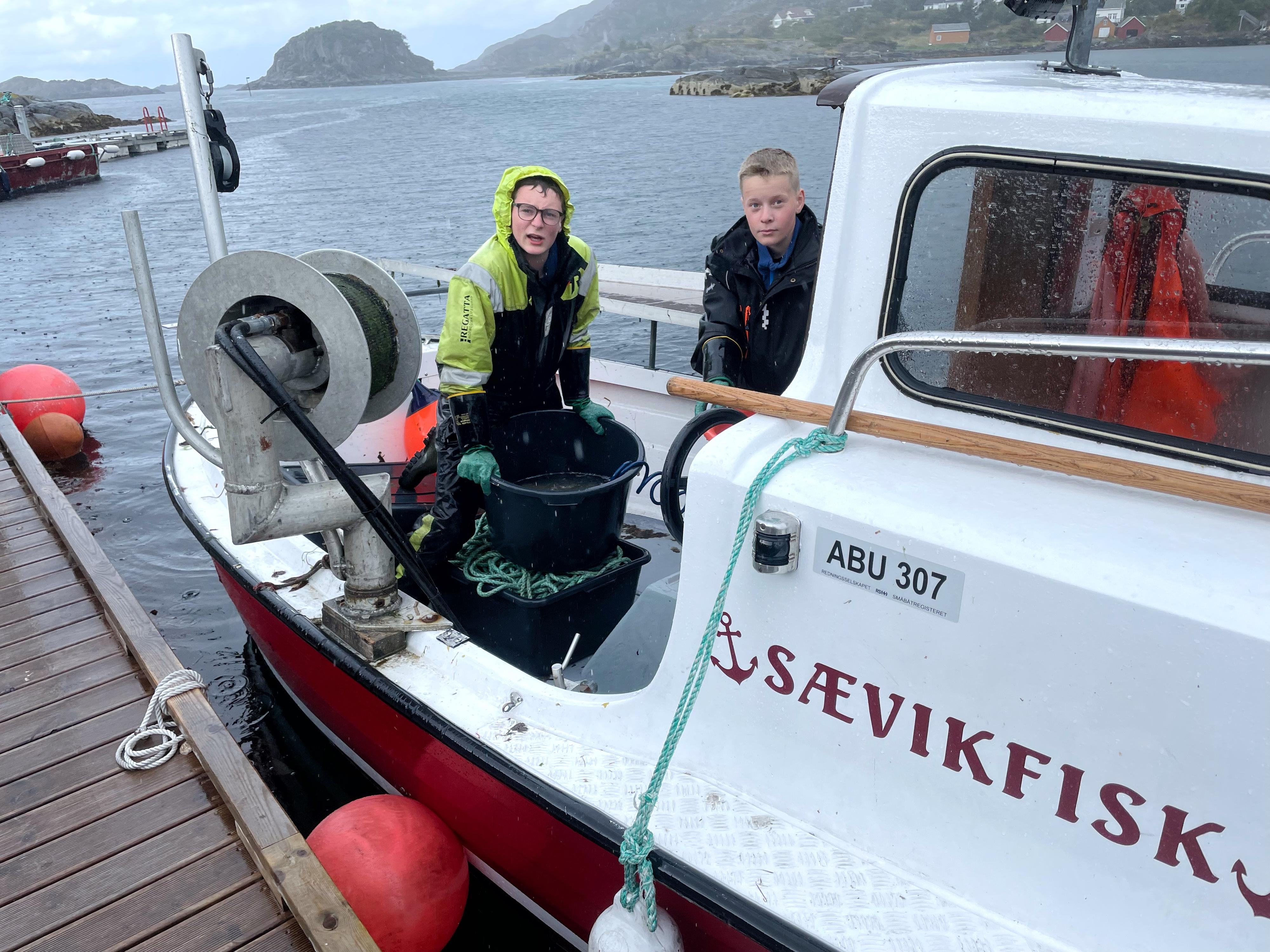 LOKALE FISKERE: Henrik Myklebust (13) og Isak Reite (14) kommer innom med nytrukket rødspette. 