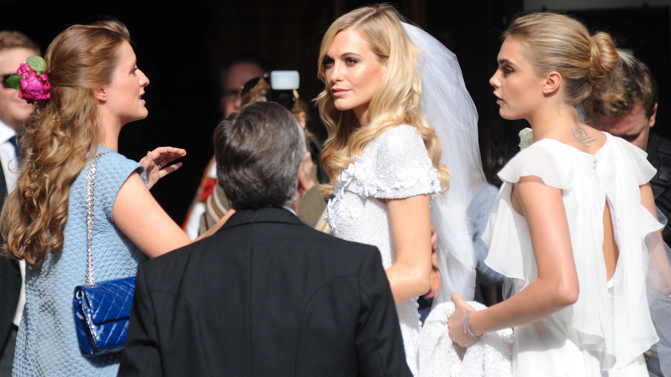 SISTER GOALS: Lillesøsteren Cara matchet bruden Poppy, i hvit kjole som var spesialsydd fra Chanel. Foto: Getty Images