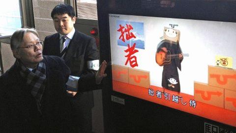 Direktør Takashi Yamamoto demonstrerer hvordan automaten har et kamera som kjenner igjen ansikter som går foran maskinen.