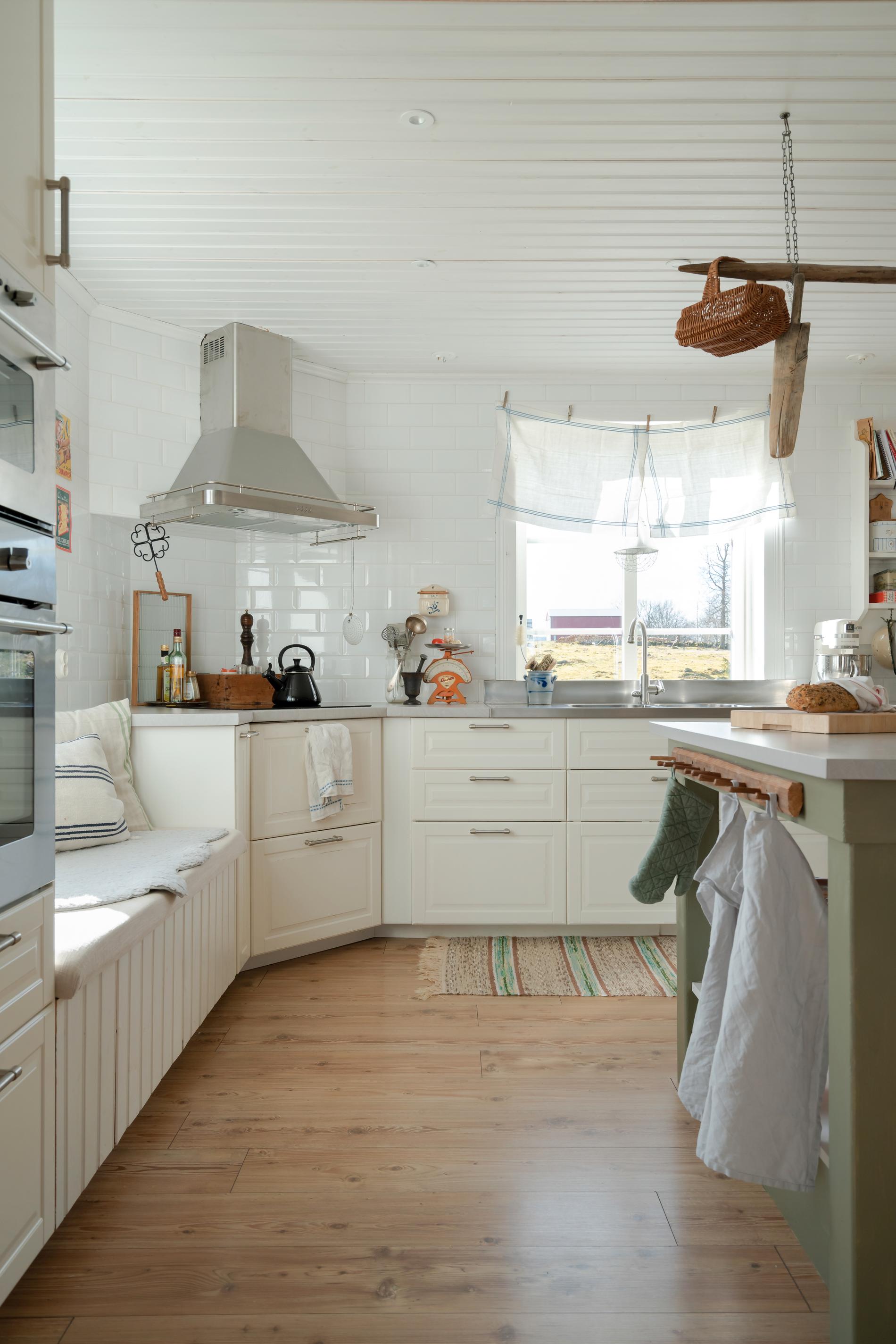 En rolig och annorlunda detalj i familjens kök är kökshanddukarna som används som gardin. Köksinredning, Ikea. Knopplisten på köksön är köpt second hand.