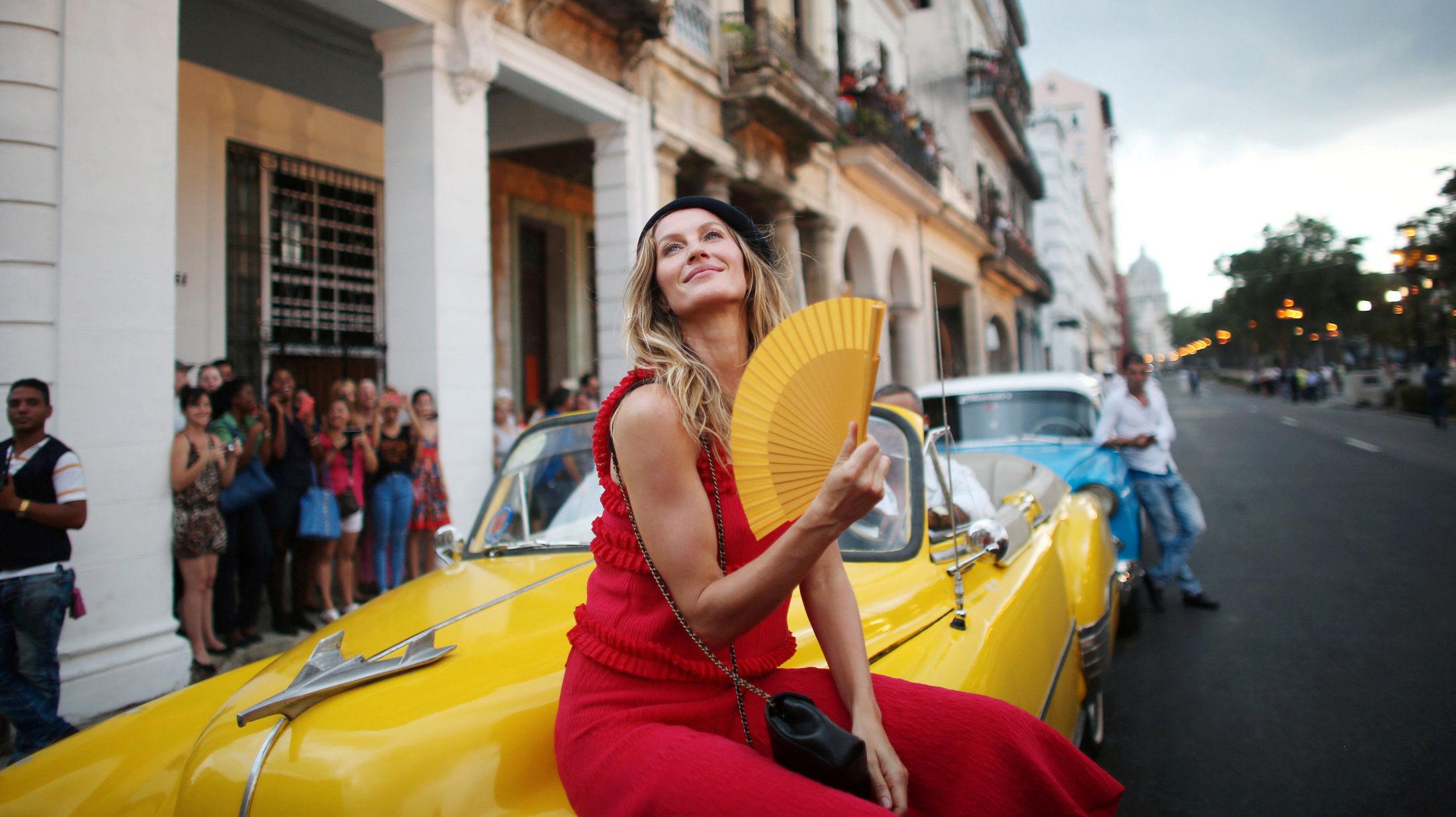 PÅ SIDELINJEN: Supermodell Gisele Bundchen fulgte for én gangs skyld catwalk-showet fra tilskuerplass - for anledningen en vintage bil. Foto: Reuters