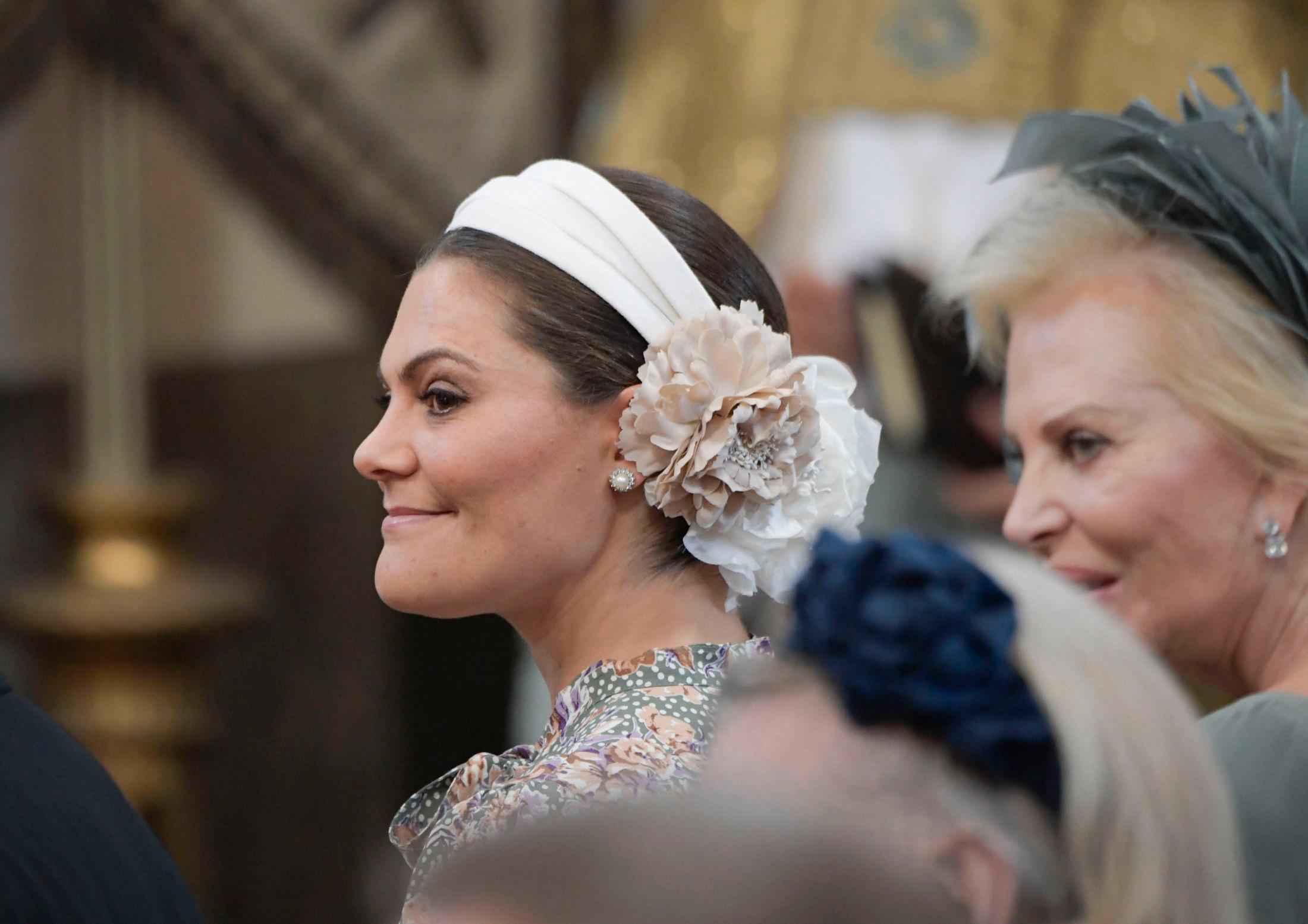 BLOMSTRET: Kronprinsesse Victoria med en stor blomst i håret i dåpen til prinsesse Adrienne. Foto: Janerik Henriksson/TT