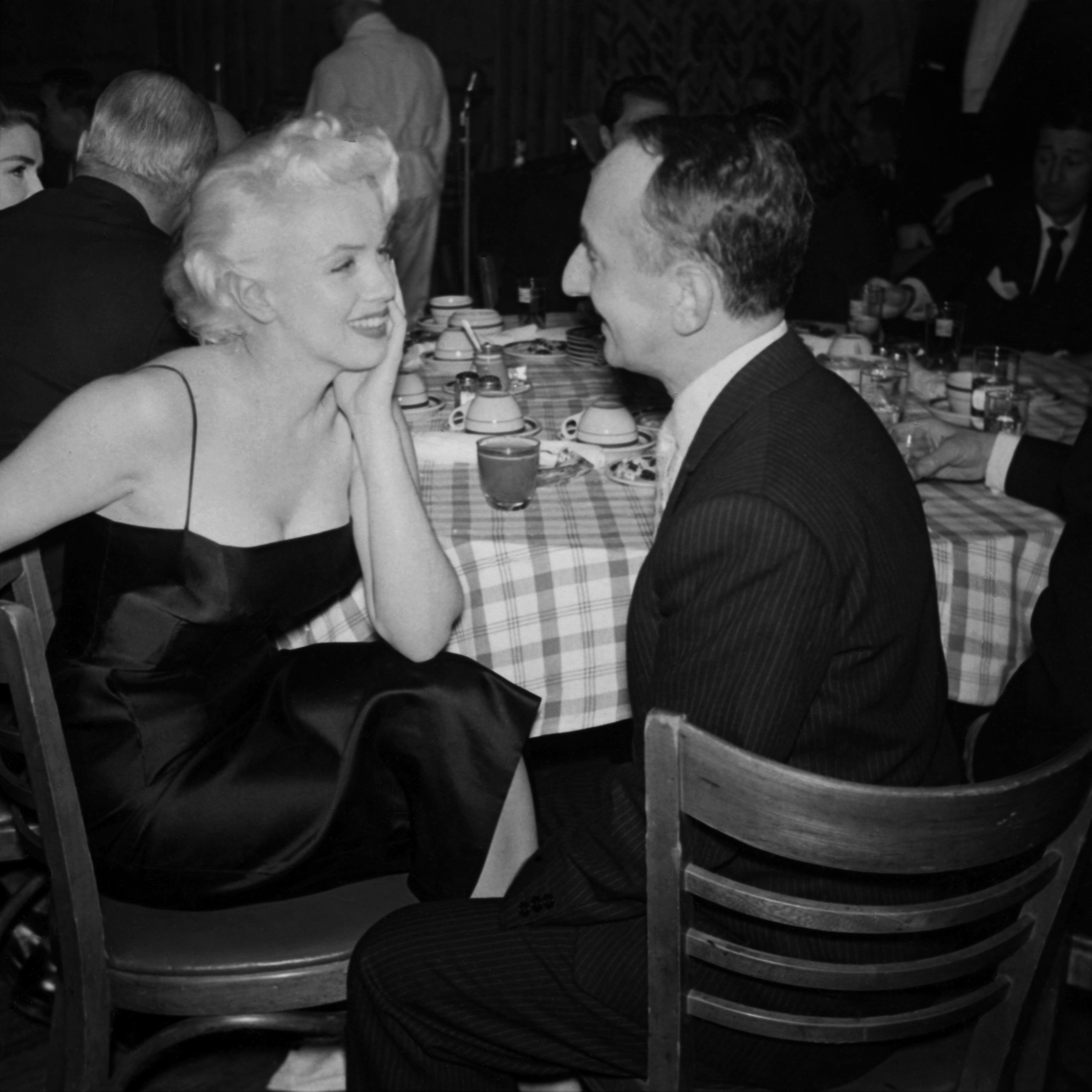TIDLØS: Med den enkle fasongen og de tynne stroppene ville kjolen Marilyn hadde på seg i 1955 ville vært like trendy i dag. Her er hun med New York Post-spaltist Leonard Lyons i 1955. 