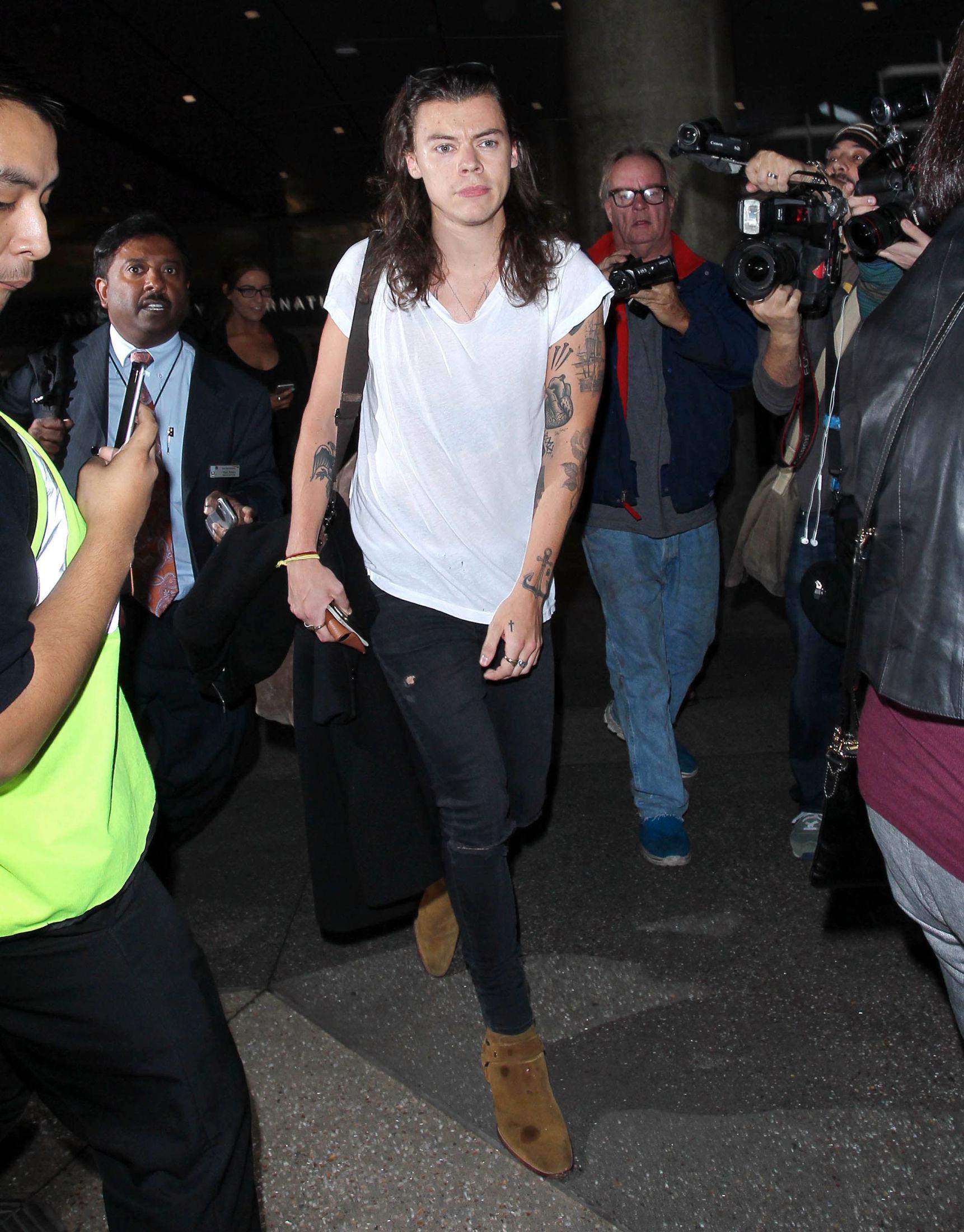 HVERDAGSLOOK: Harry Styles på flyplassen i Los Angeles ikledd rocka skinny jeans, hvit T-skjorte og brune boots. Foto: Pa Photos