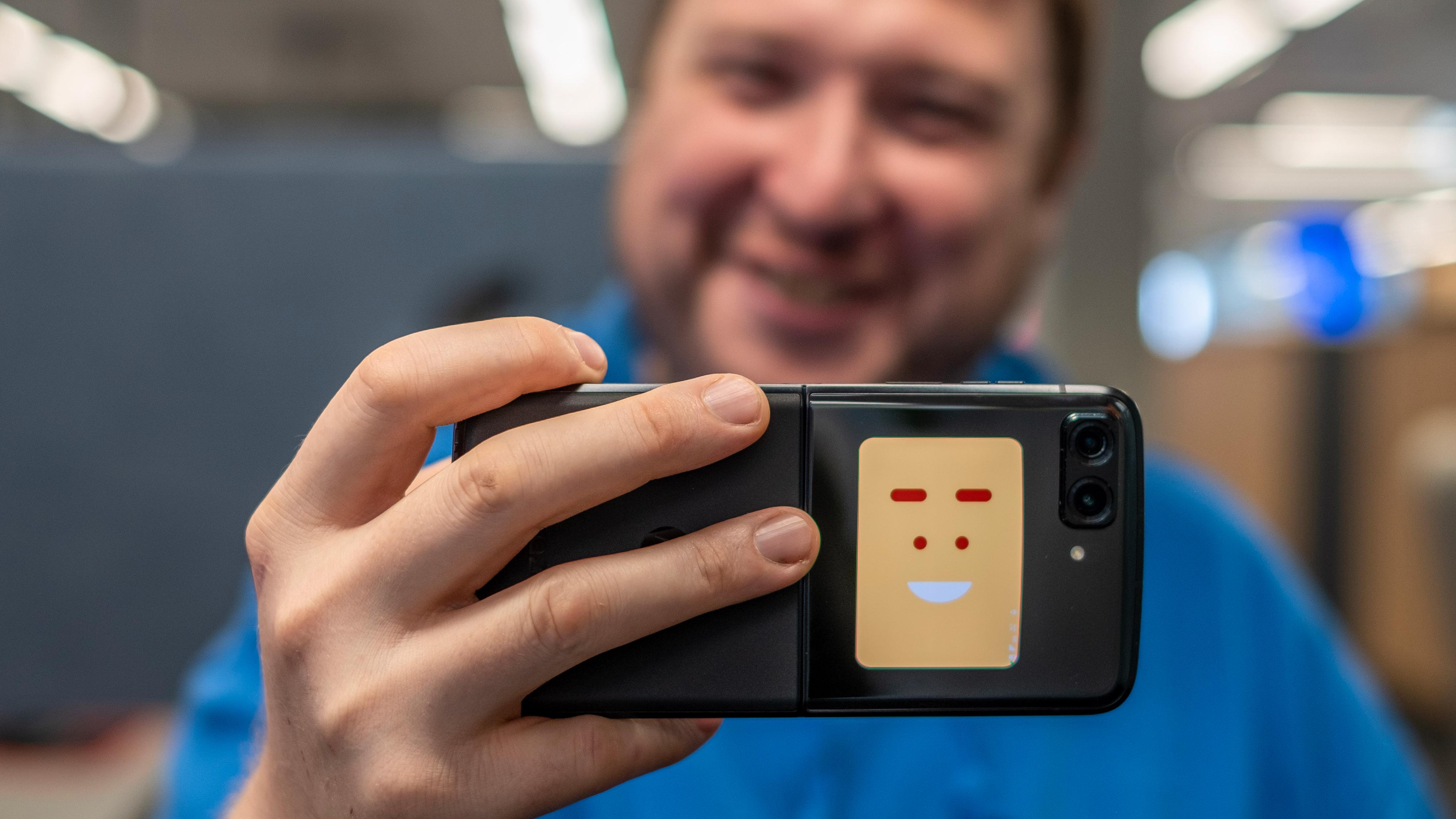 Telefonen kan vise den du fotograferer at den skal smile, eller så kan den forhåndsvise bildet du er i ferd med å ta.