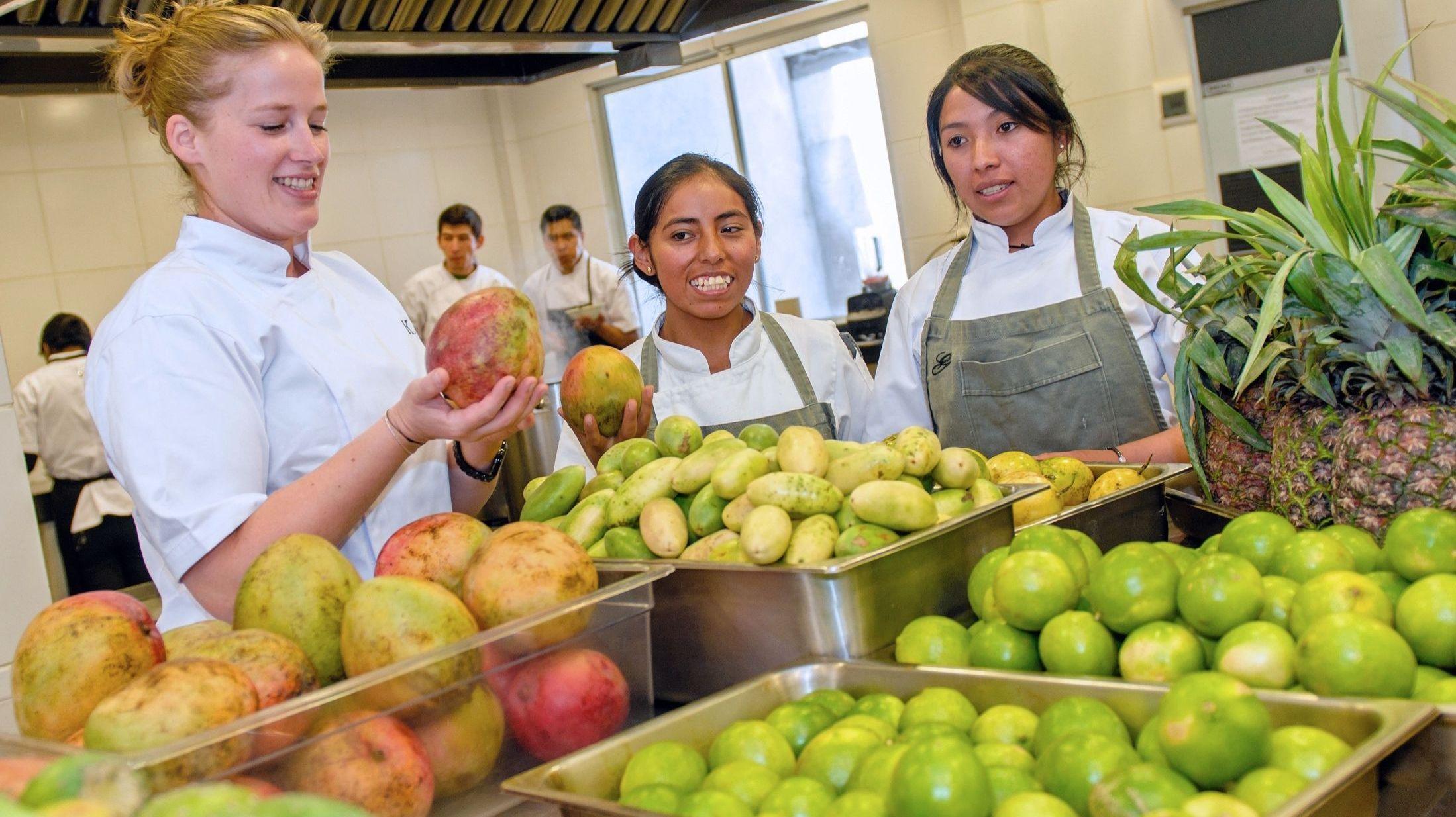 I LÆRE: Her er Seidler i 2016 på kjøkkenet til Gustu, sammen med to studenter ved restaurantens kokkeopplæring.  Foto: AFP