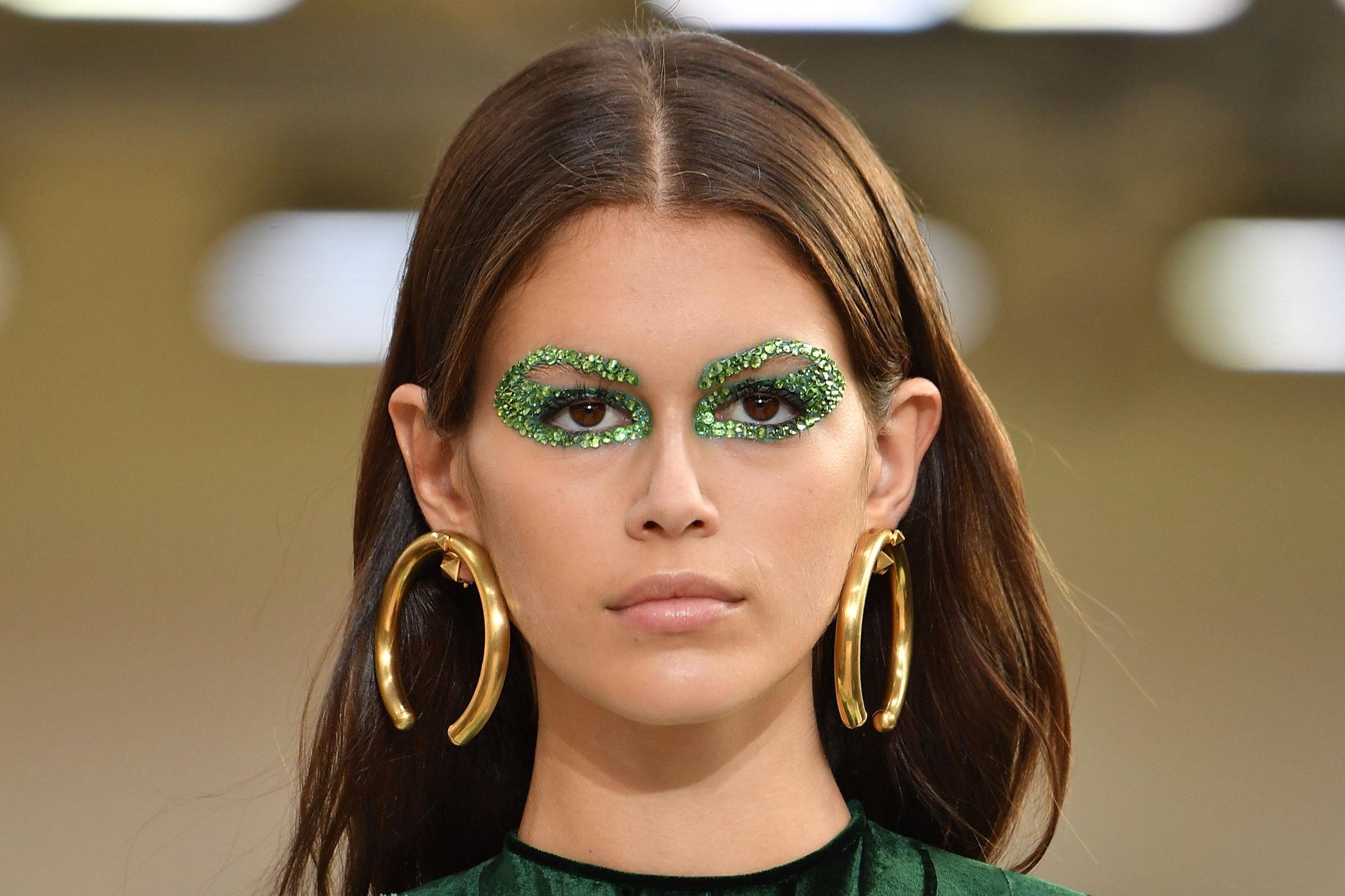 PÅ CATWALKEN: Supermodell Kaia Gerber på catwalken for Valentino under Paris Fashion Week. Glitter rundt øyene var tydelig en av trendene. Foto: Getty Images