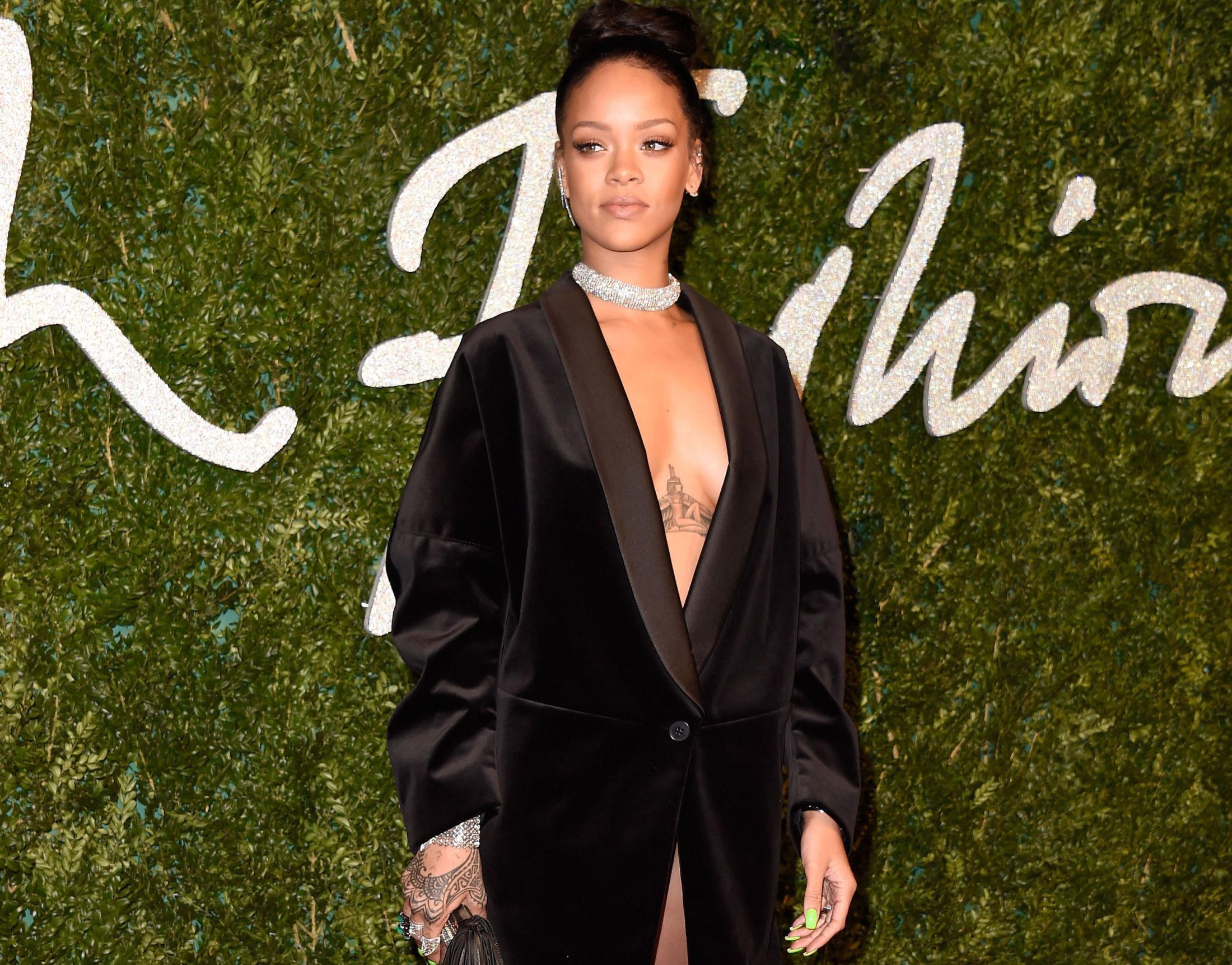 ALL IN: Rihanna går verken forsiktig til verks når hun lager musikk, eller pynter seg. Vi har ikke oversikt over hvor mange tatoveringer superstjernen har, men de to mest synlige på dette bildet er hvertfall henna-blekket på høye hånd og den egyptiske engelen mellom brystene. Foto: Getty Images