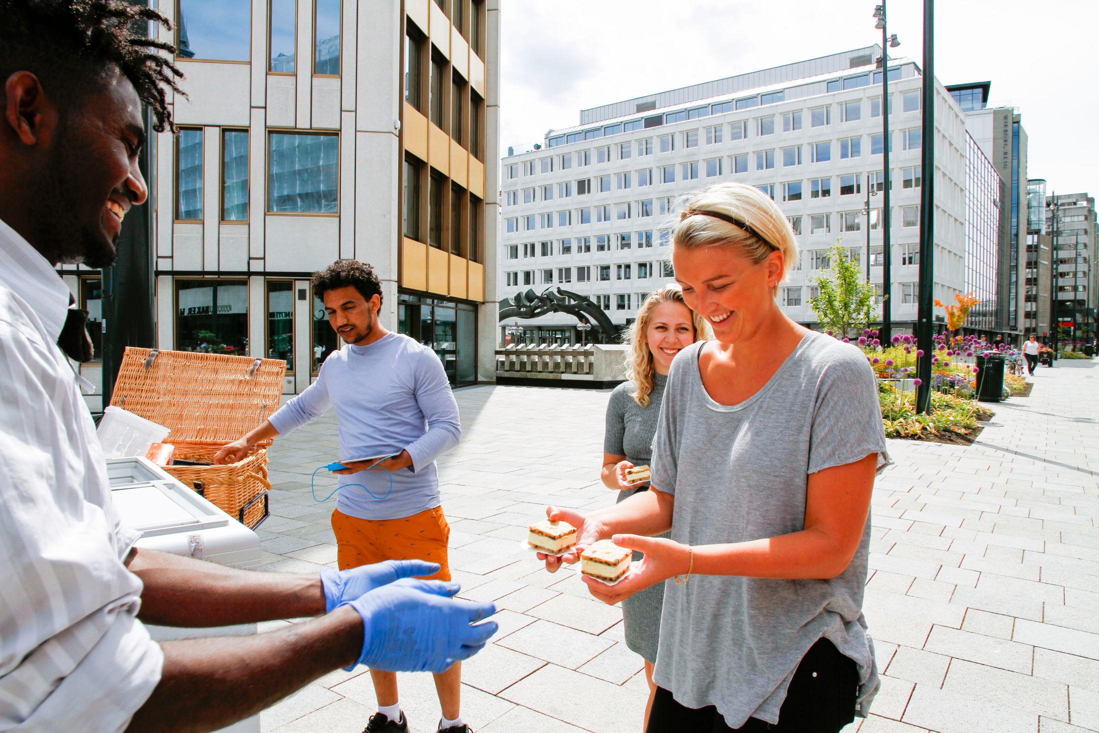 FORNØYDE: Mikiele Okvbay (t.v.) og Ermias Debesay selger iskalde is-sandwich til kundene Julie Olafsrud (bak) og Emma Aakenes i solsteika på Vikaterrassen.