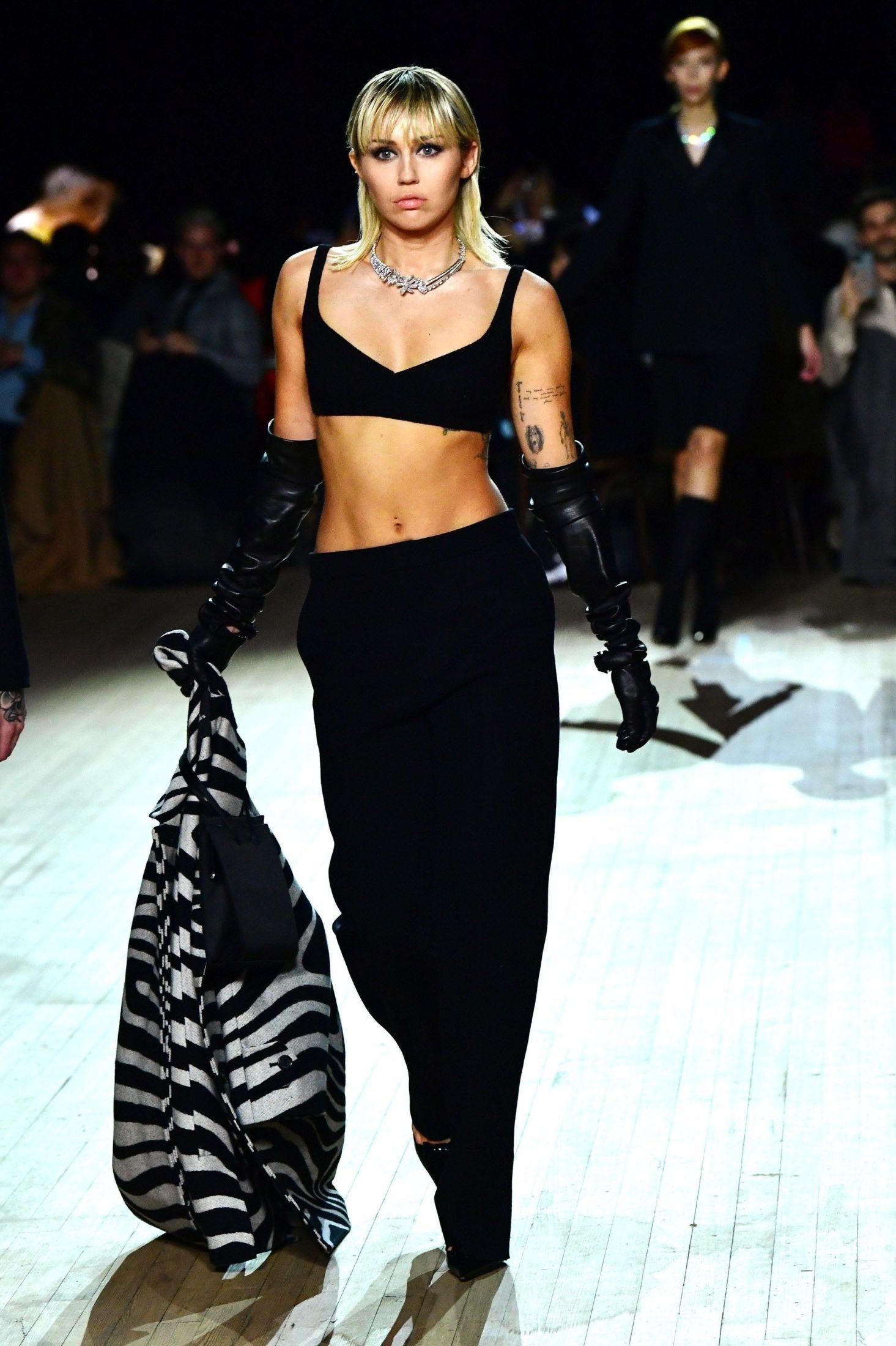 I FARTA: Her går Miley Cyrus på catwalken. Hun var kledd i svarte bukser og svart BH-topp. I hånden holdt hun en zebramønstret blazer. Foto: Slaven Vlasic/Getty Images for Marc Jacobs/AFP.