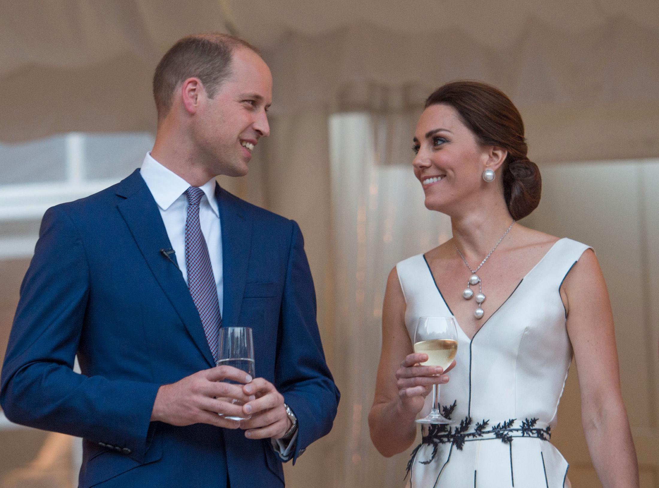 HVITE PERLER: Hertuginnen og prins William så ut til å storkose seg under Queen Elizabeth II hagefest. Kate har på seg matchende perlesmykker til den hvite cocktail-kjolen. Foto: Getty Images.