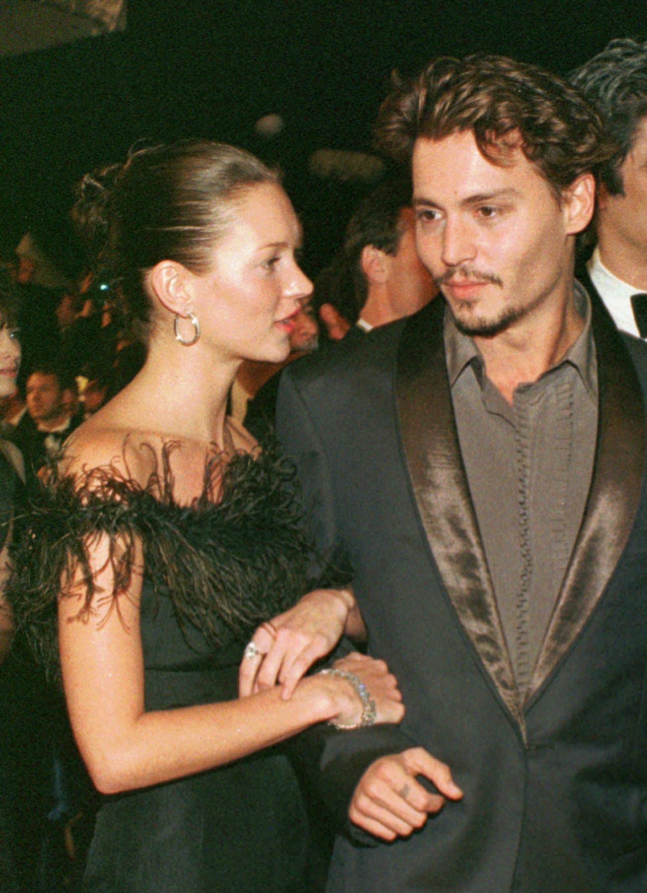Kate Moss og Johnny Depp i Cannes i 1998. Kjolen til Moss har blitt kopiert av merker utallige ganger siden, og hun har selv brukt tilsvarende svarte kjoler med fjær på i ettertid. 