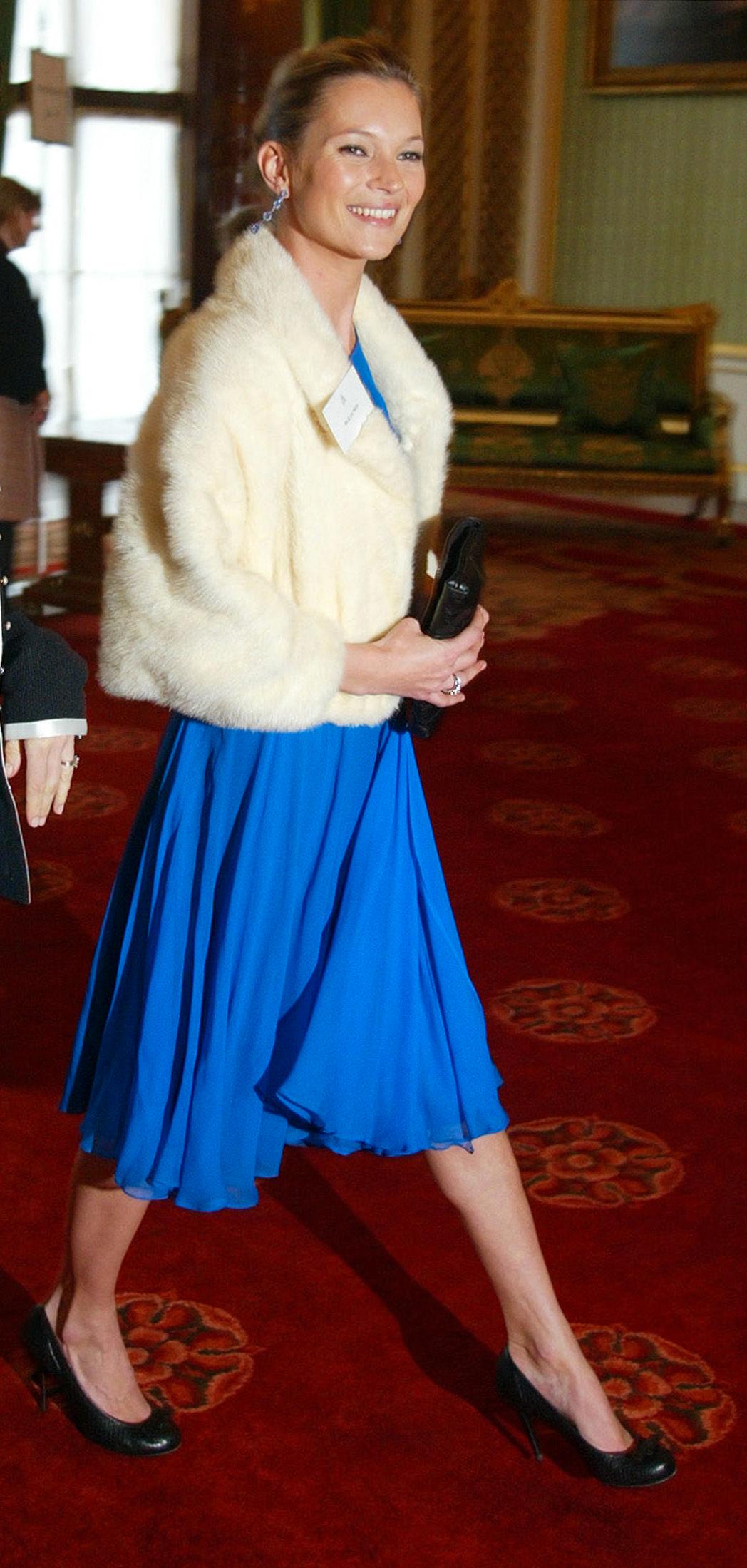 KLAR FOR Å MØTE DRONNINGEN: Kate Moss på vei til et arrangement på Buckingham Palace ikledd en blå kjole, pelsjakke og pumps. Foto: Mike Finn-Kelcey, Reuters