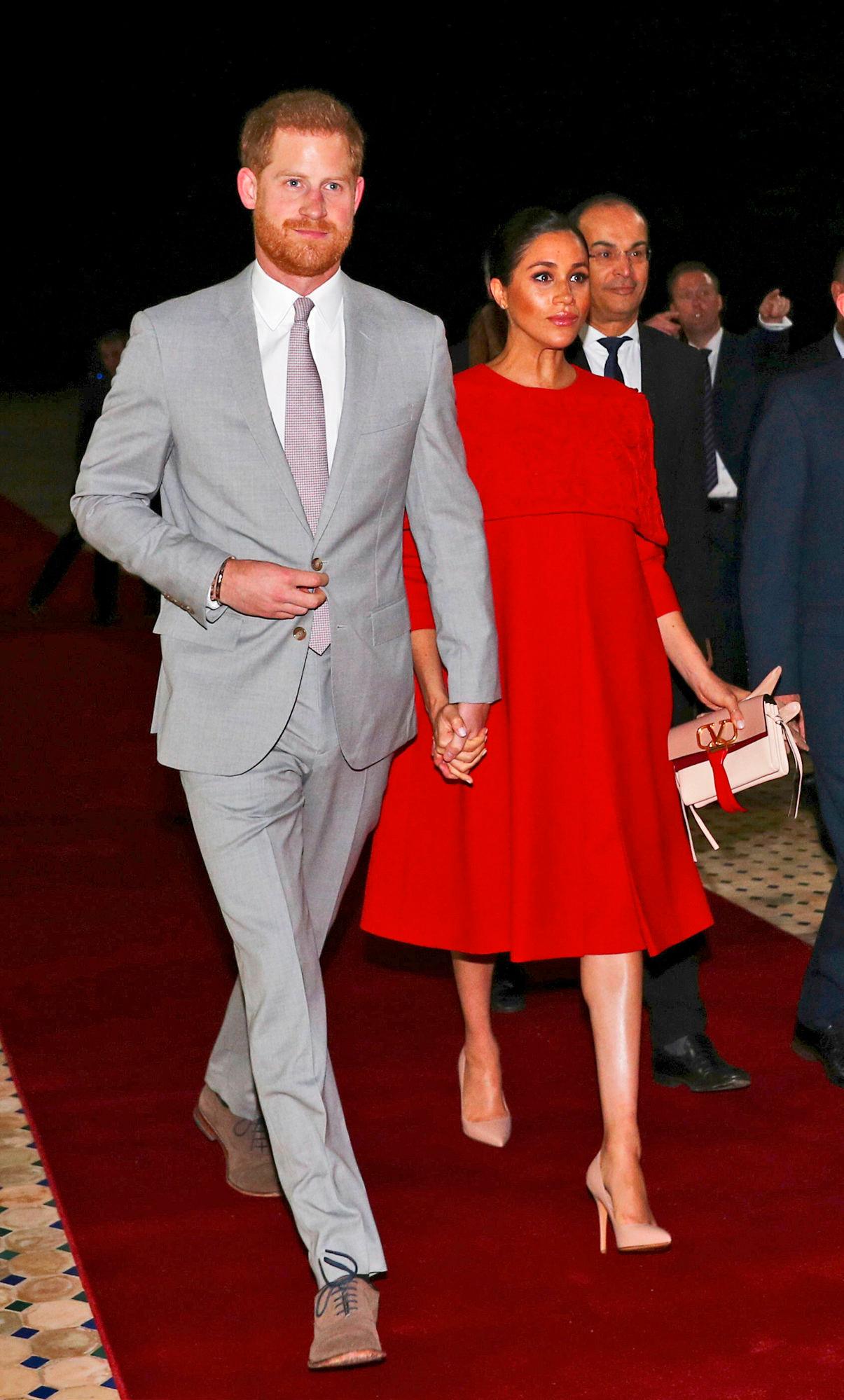 STILIG PAR: Prins Harry og hertuginne Meghan på vei til middag i Casablanca. Prinsen hadde lysegrå dress mens hertuginnen hadde knallrød kjole. Foto: AP.