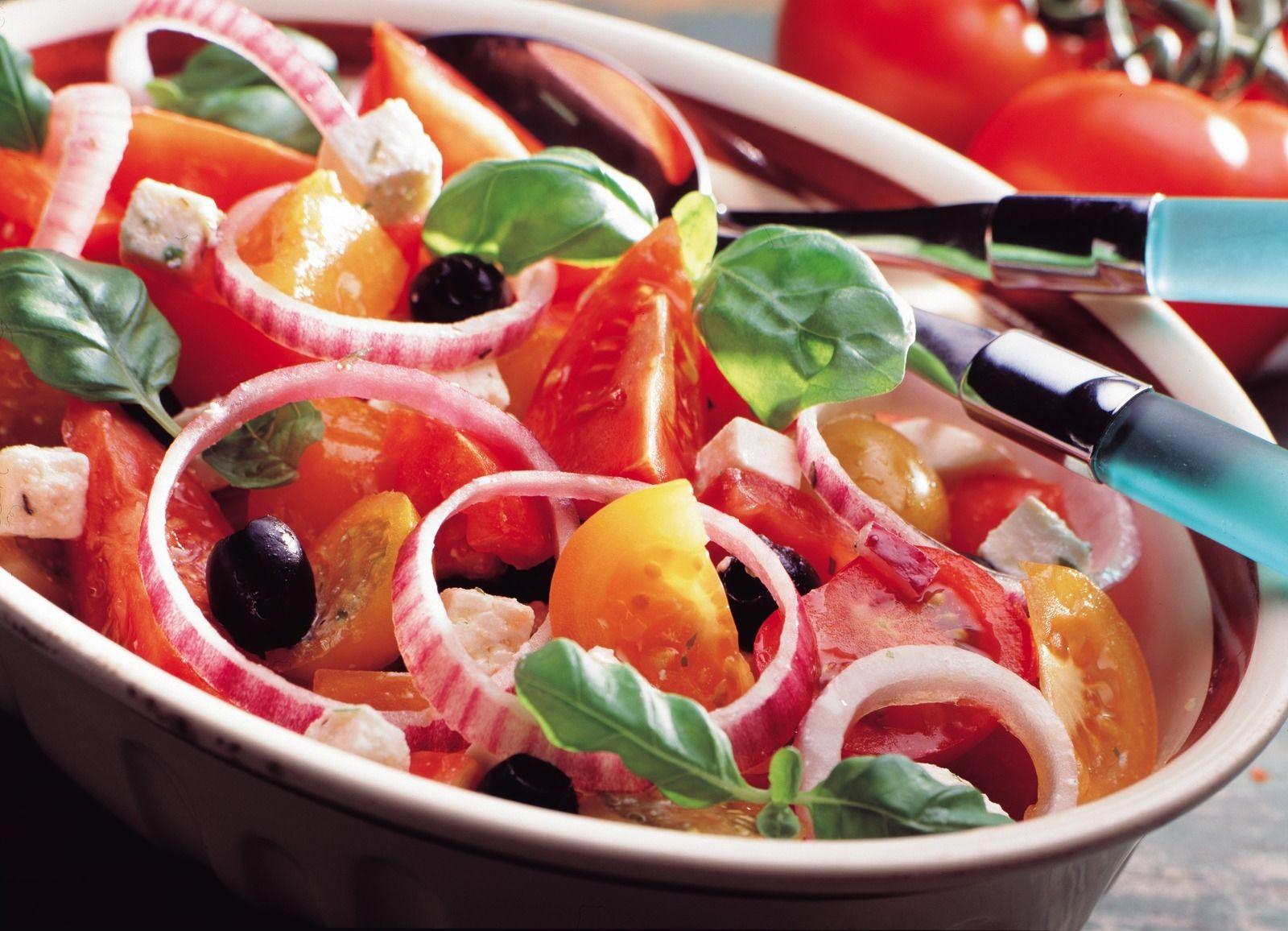 Deilig tomatsalat med rødløk, basilikum, oliven og fetaost. (Foto: Opplysningskontoret for frukt og grønt/Kim Holthe.)
