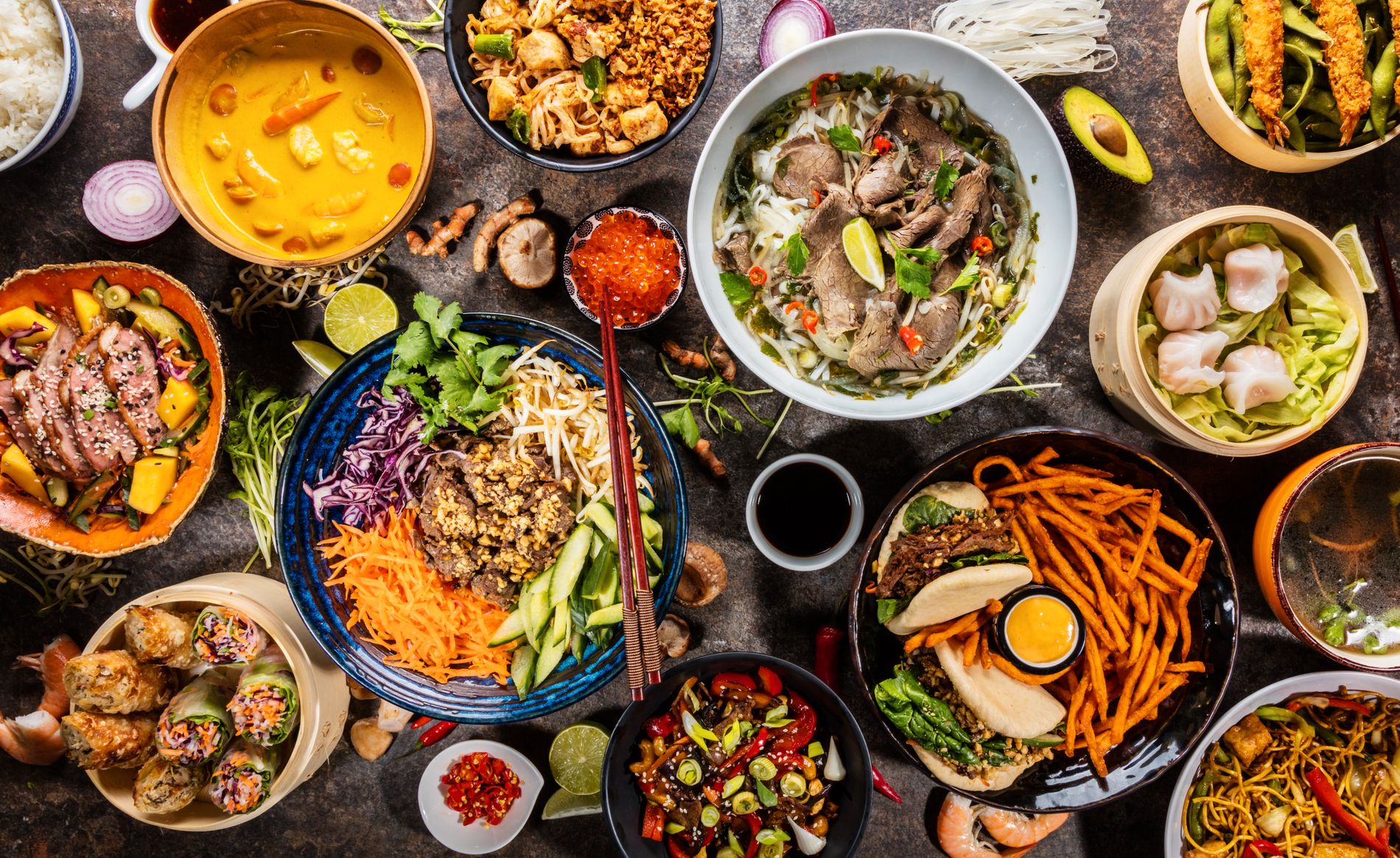 Olika asiatiska maträtter i skålar ovanifrån