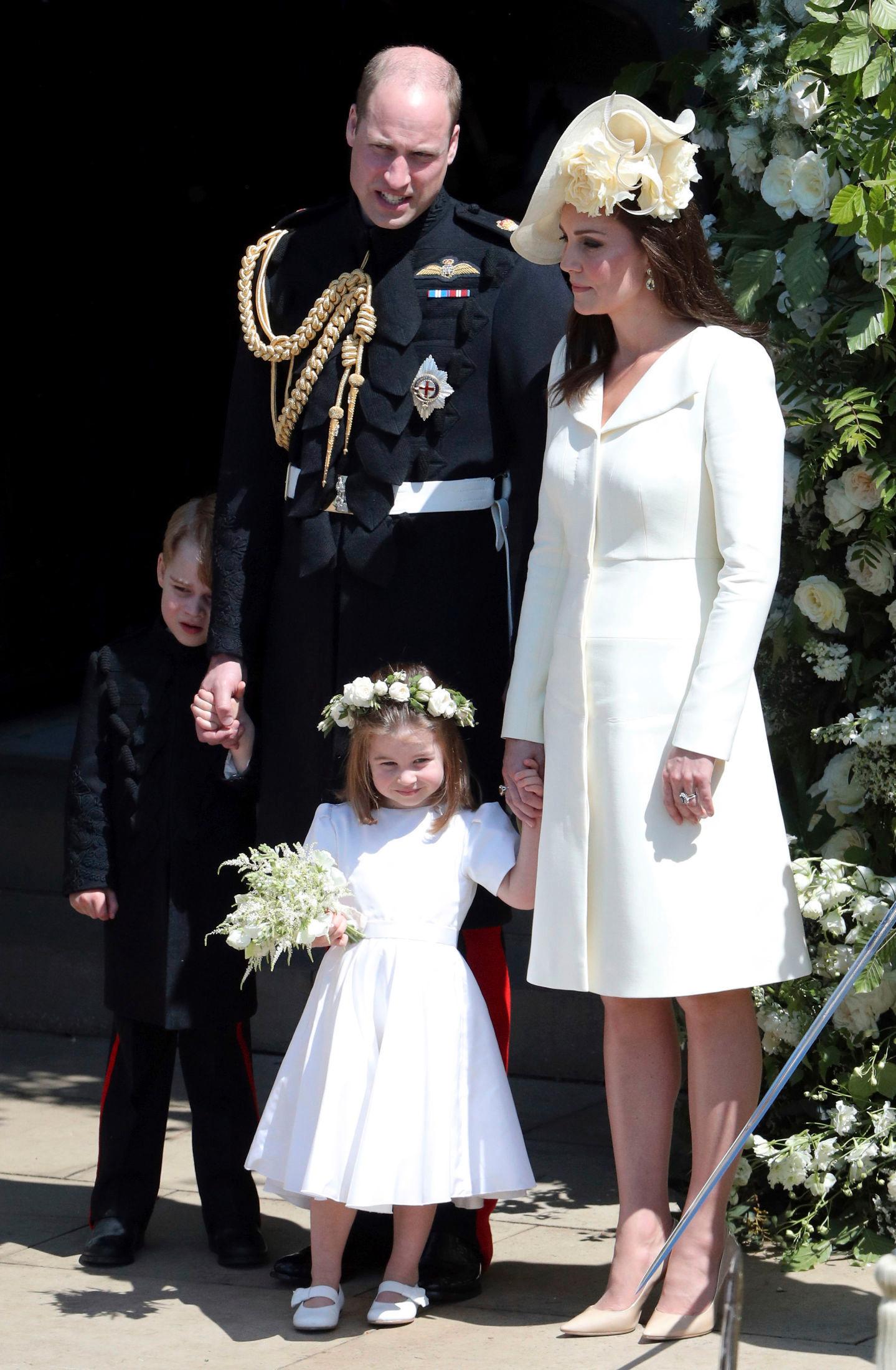 FAMILIEN PÅ TRAPPEN: Hertuginne Kate i kåpe fra Alexander McQueen sammen med datteren prinsesse Charlotte som var brudepike, prins William som var forlover, og prins George som var brudesvenn. Foto: AP