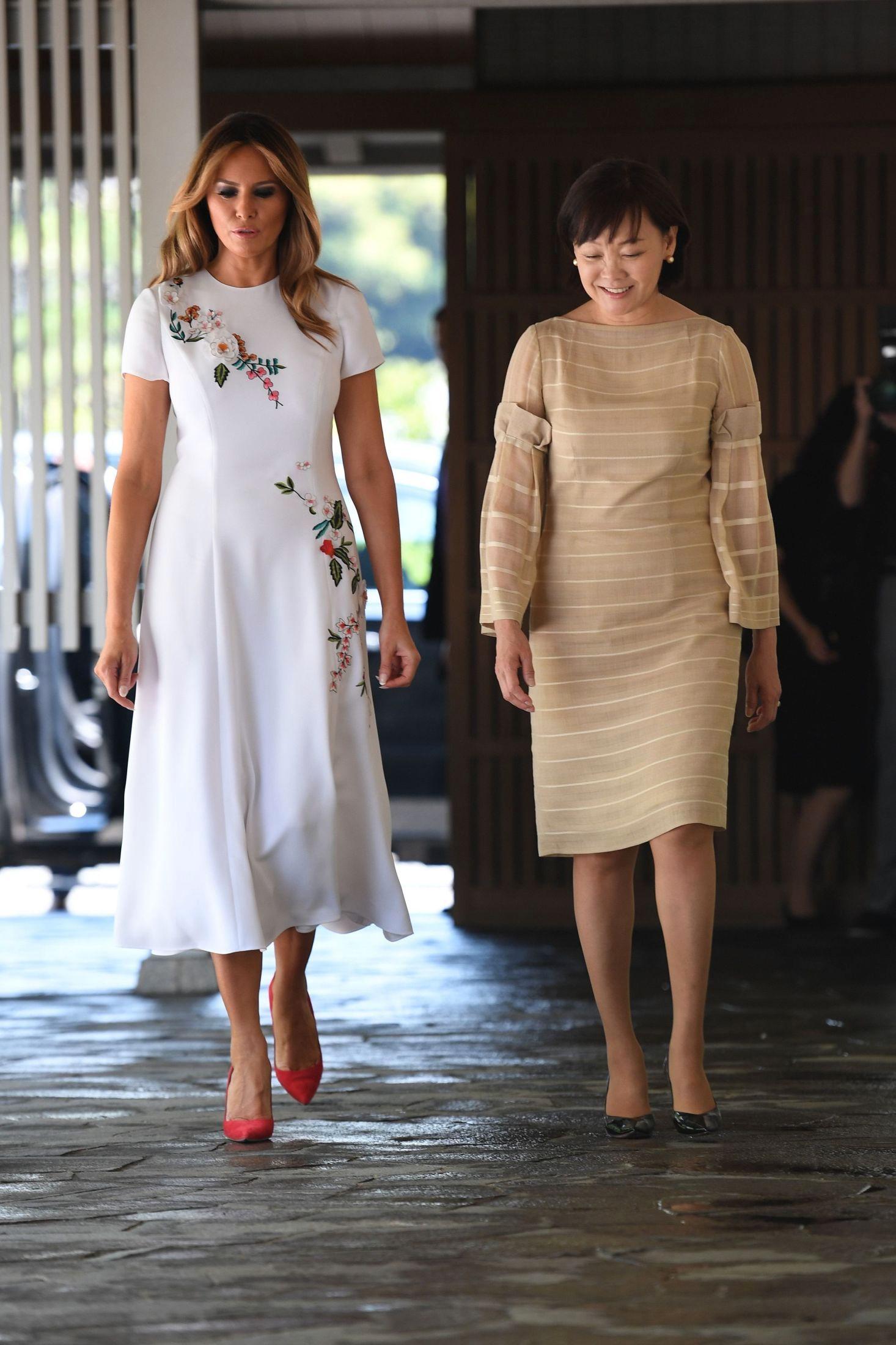 LUKSUSKJOLE: Melania Trump i hvit kjole med blomsterbroderier fra Carolina Herrera. Her sammen med kona til Japans statsministeren, Akie Abe. Foto: AFP