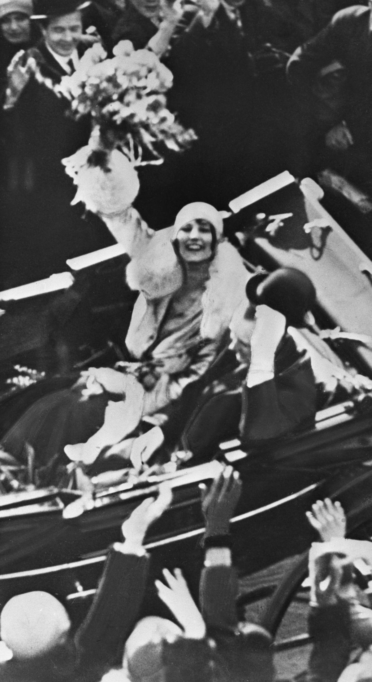 Her vinker prinsesse Märtha glad med blomsterbukett i hånden i forbindelse med bryllupet 21. mars 1929. Foto: NTB