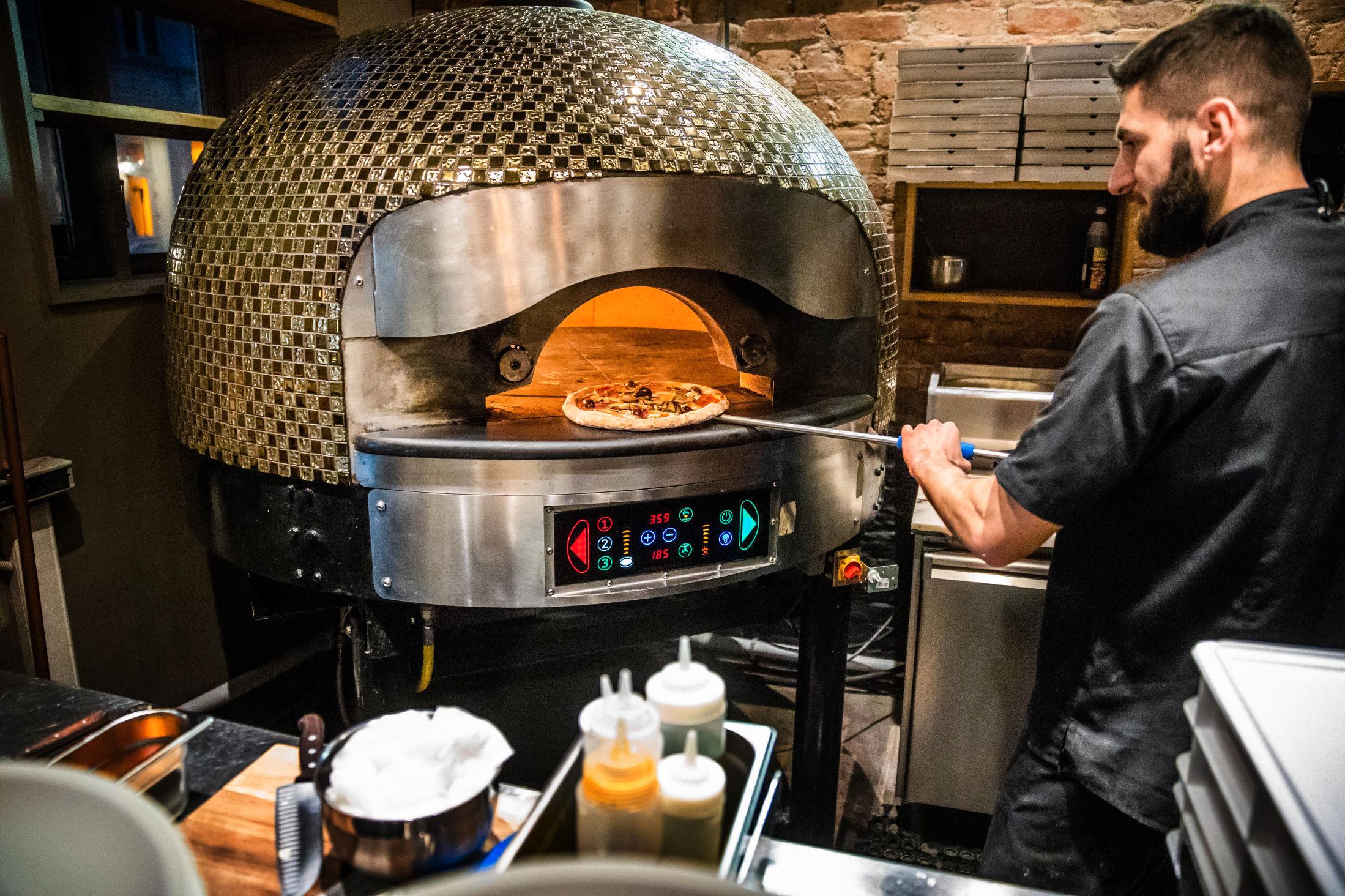 ITALIENSK STIL: Alle pizzaene bakes i stenovn. Foto: Frode Hansen/VG