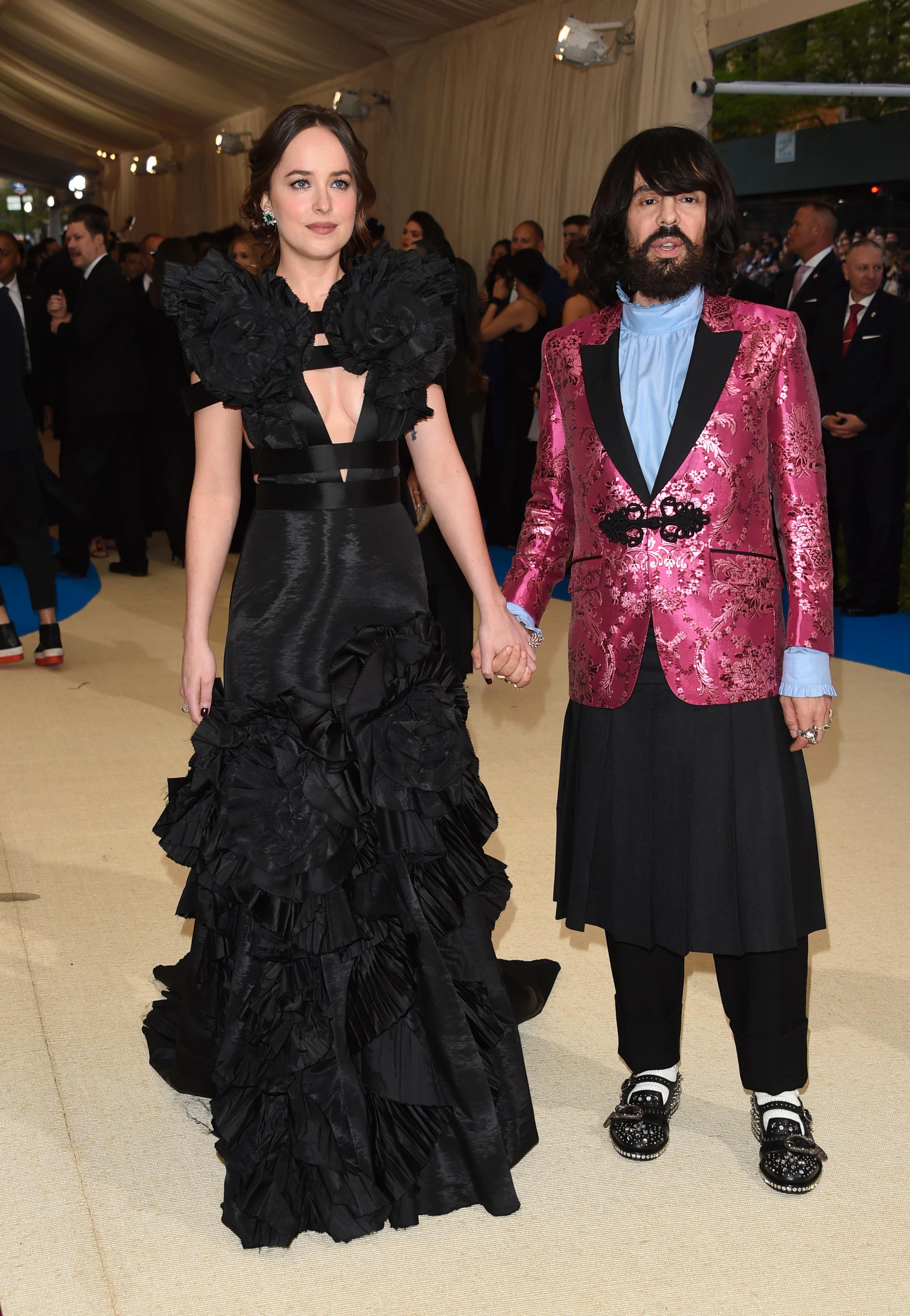 MUSE? Gucci-designer Alessandro Michele (t.h.) hånd i hånd med Dakota Johnson. Hun har vært å se i mange Gucci-antrekk de siste årene. Her på Met-gallaen i 2017.