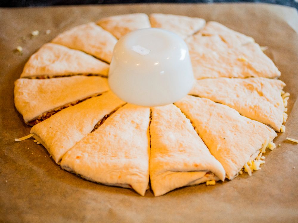Placera en skål i mitten och skär pizzan som en stjärna och vrid varje slice.