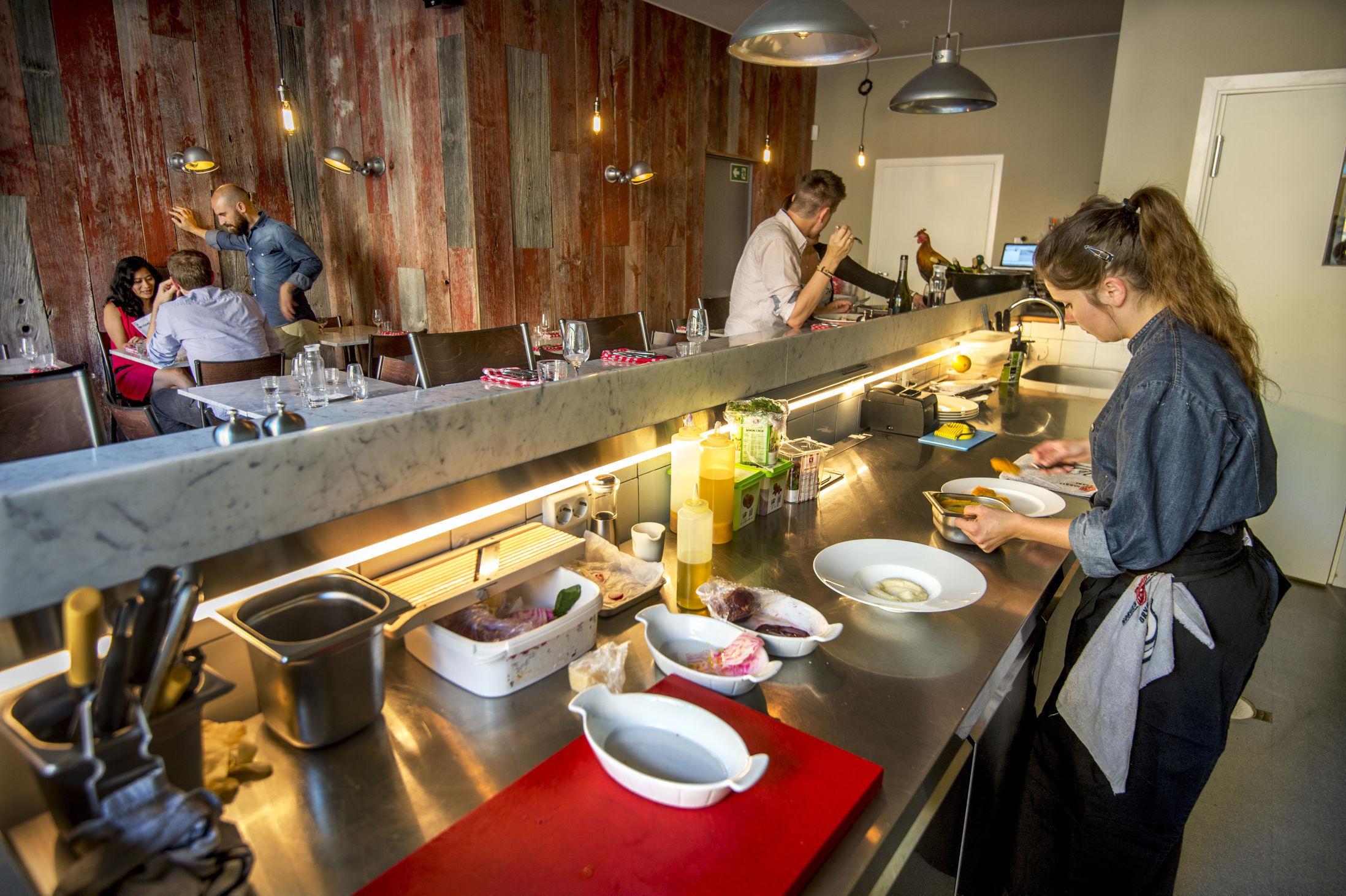 INNBYDENDE: Lokalene til Rotisserie er en vellykket miks av rustikk og moderne, og fra baren ser man rett inn på det åpne kjøkkenet. Foto: Helge Mikalsen/VG.