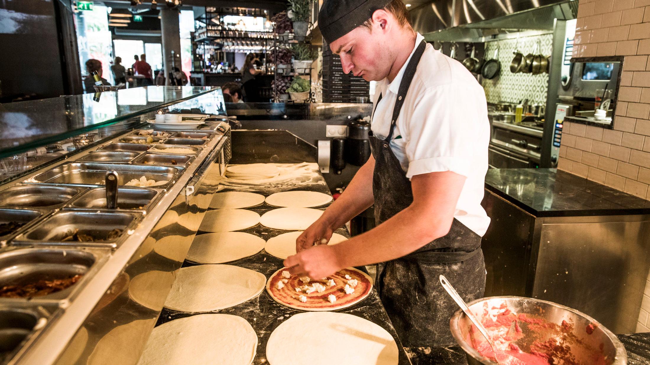 I FULL SVING: På kjøkkenet er de travle med å få ut pizza til sultne gjester. Foto: Frode Hansen/VG